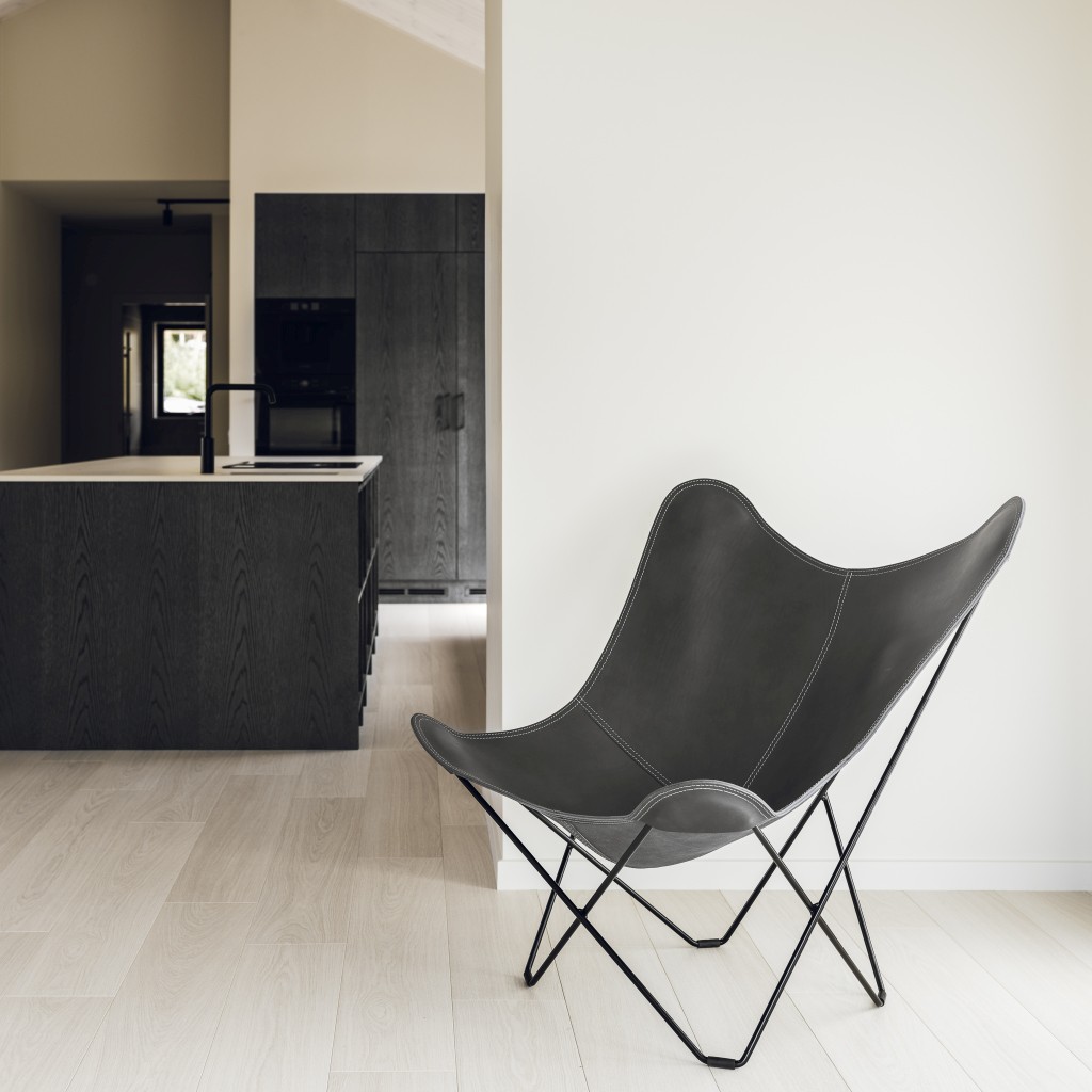 Grauer Pampa Mariposa Butterfly Chair Ledersessel mit schwarzem Metallgestell in modernem Wohnraum.