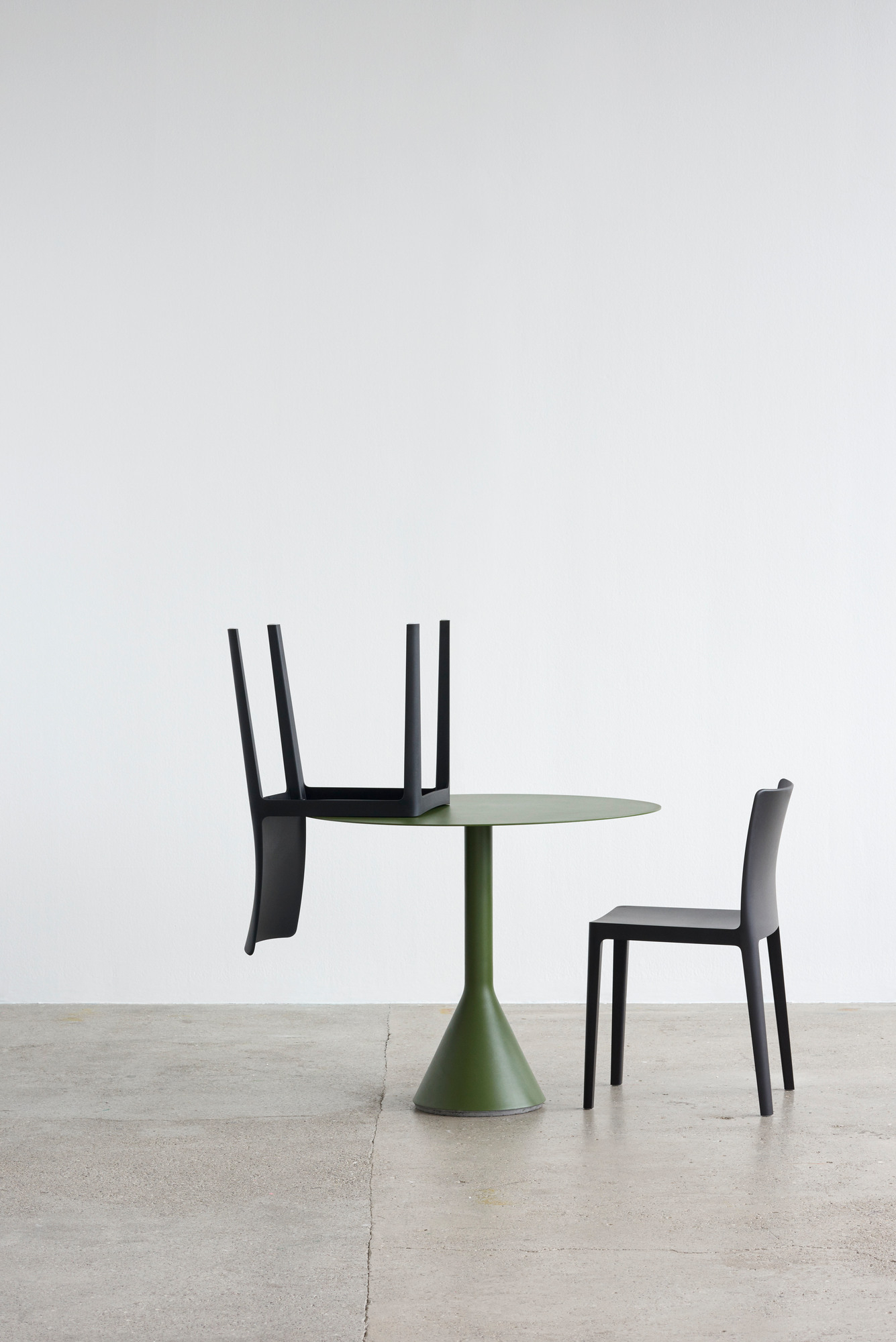 Élémentaire Stuhl in Rauchgrün von Hay: Outdoor-Stuhl neben grünem Tisch, minimalistisches Design.