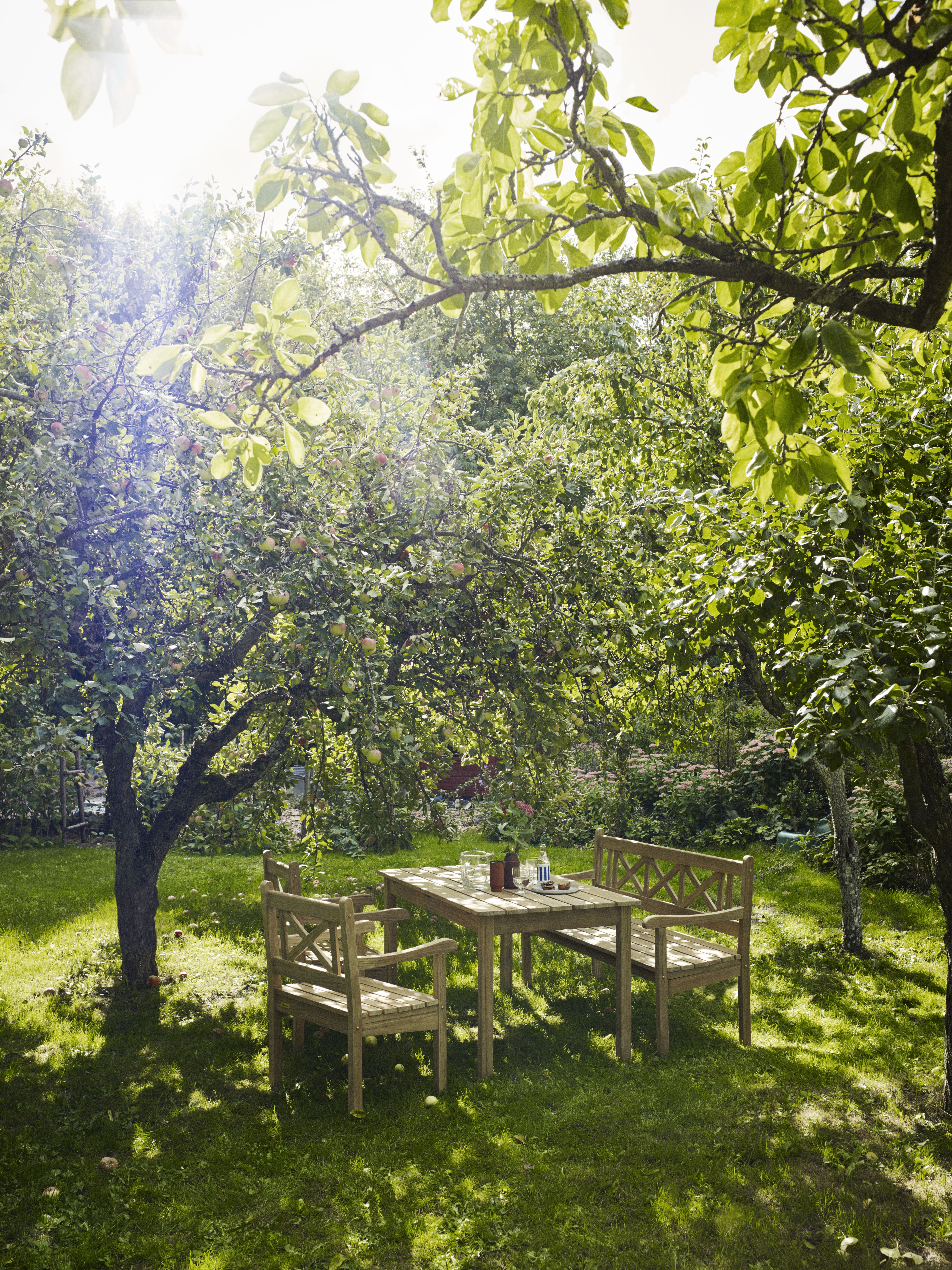 Skagen Gartenmöbel Set von Skagerak by Fritz Hansen unter einem schattigen Baum auf einer Wiese.