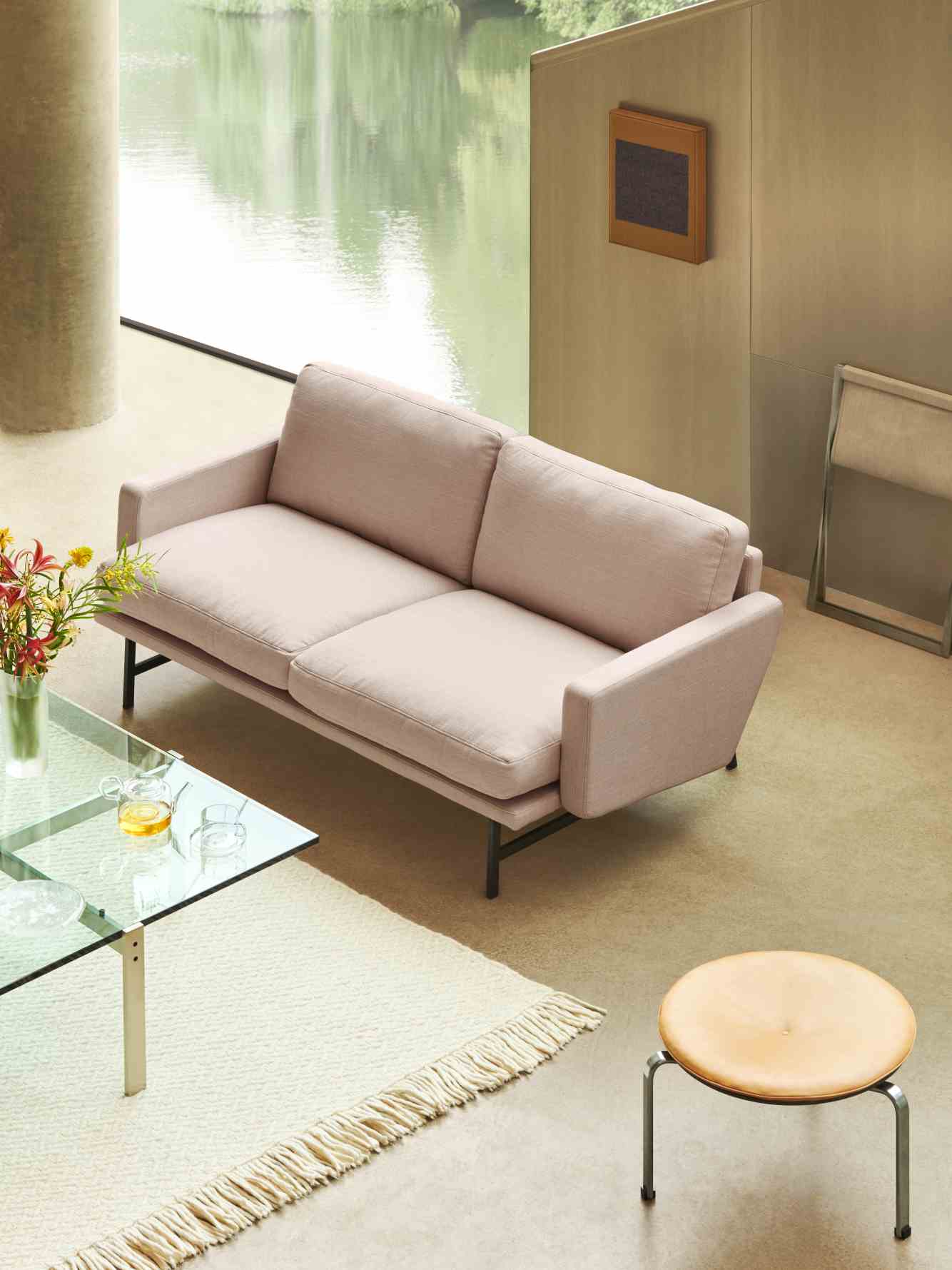 Beiges Lissoni Sofa von Fritz Hansen im modernen Wohnzimmer mit Glascouchtisch und Hocker.