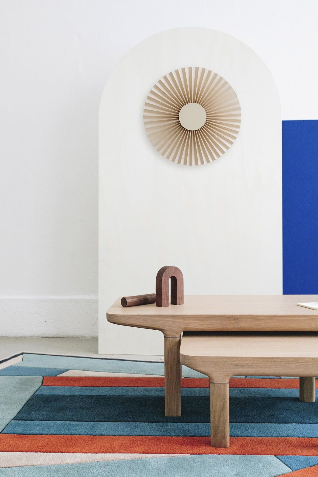 Camille Couchtisch aus hellem Holz, minimalistisches Design mit Holzdekoration auf farbenfrohem Teppich.