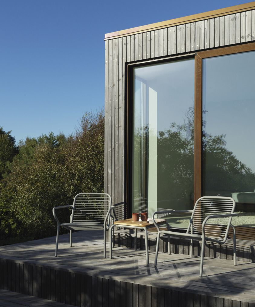 Zwei graue Vig Lounge Chair Sessel von Normann Copenhagen mit kleinem Tisch im Freien.