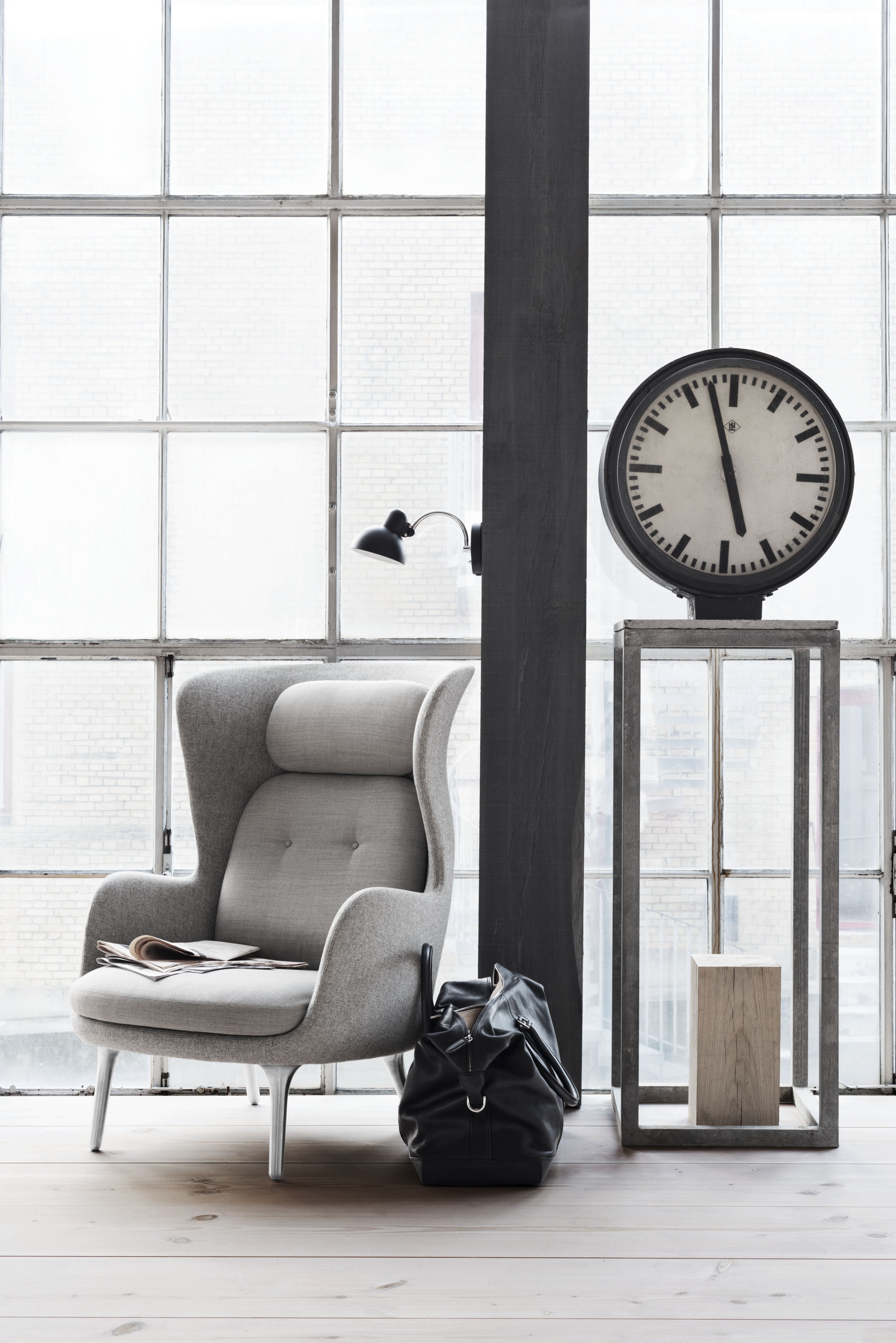 Grauer Ro Sessel von Fritz Hansen mit hoher Rückenlehne und Kopfstütze vor Fenster. Design Möbel.