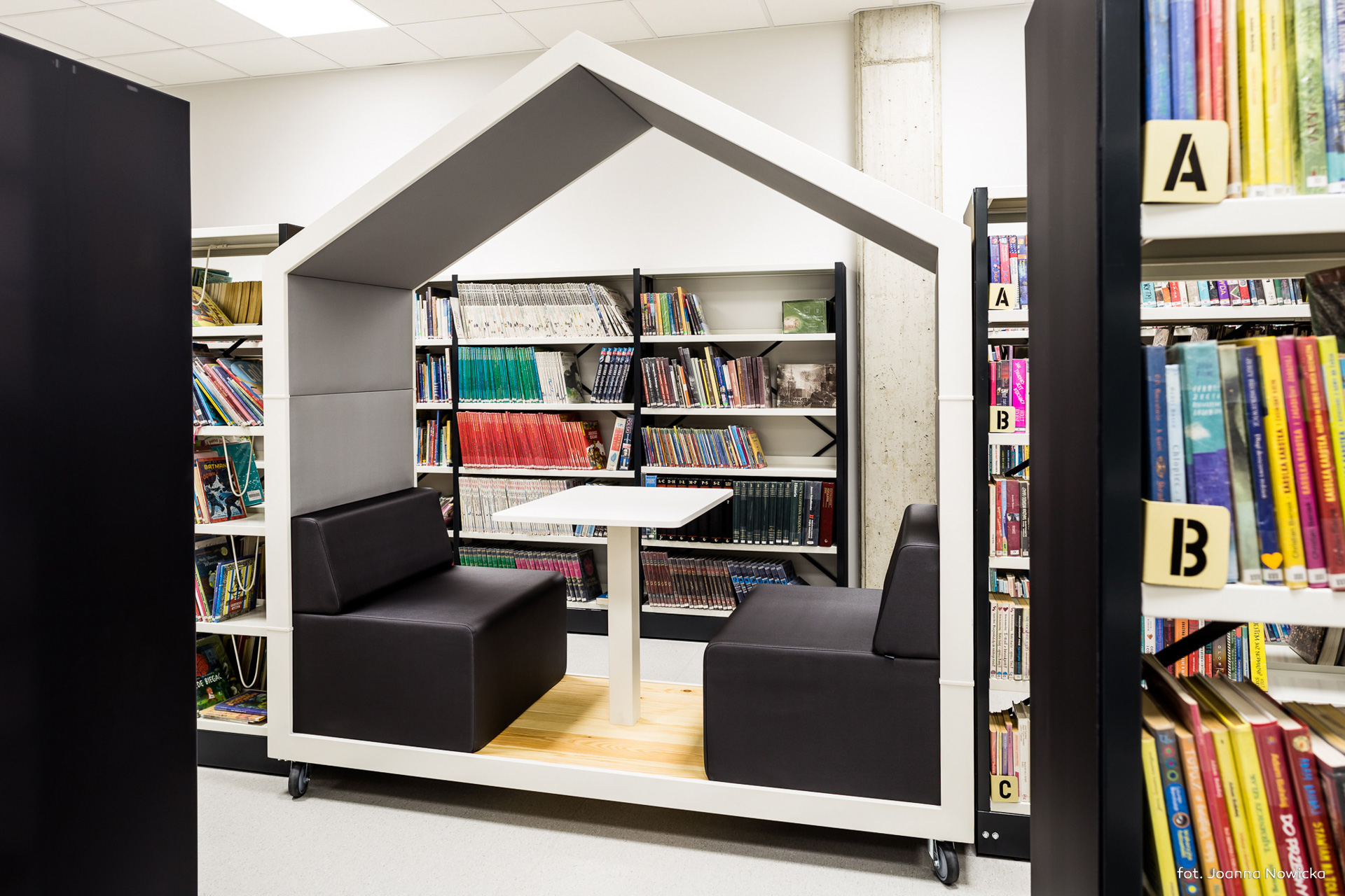treehouse TH 2 Akustikmöbel von Bejot für zwei Personen in einer Bibliothek mit Bücherregalen.