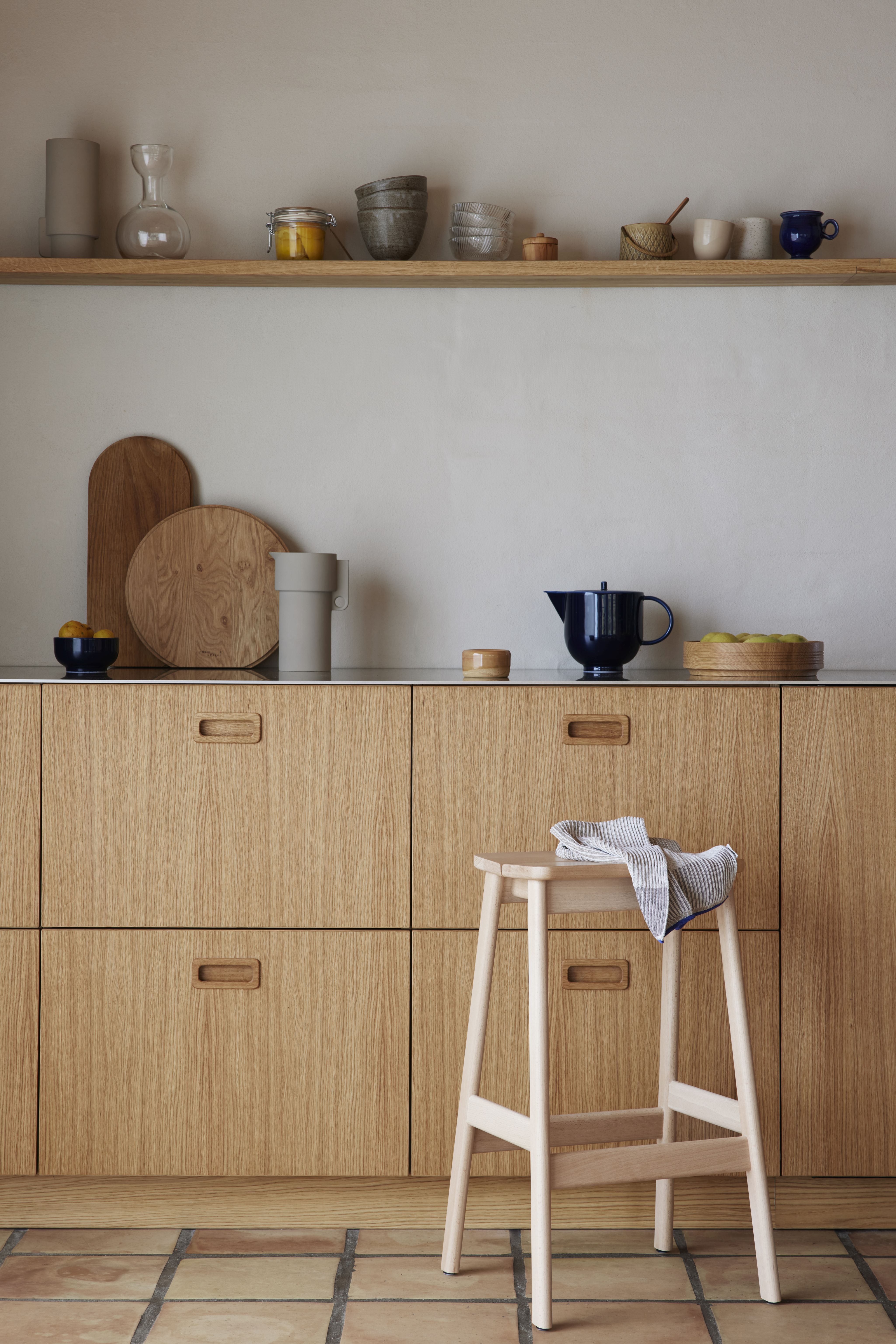 Angle Barhocker von Form & Refine, gebeizt schwarz, vor Küchenschränken. Moderner Holz-Barstuhl.
