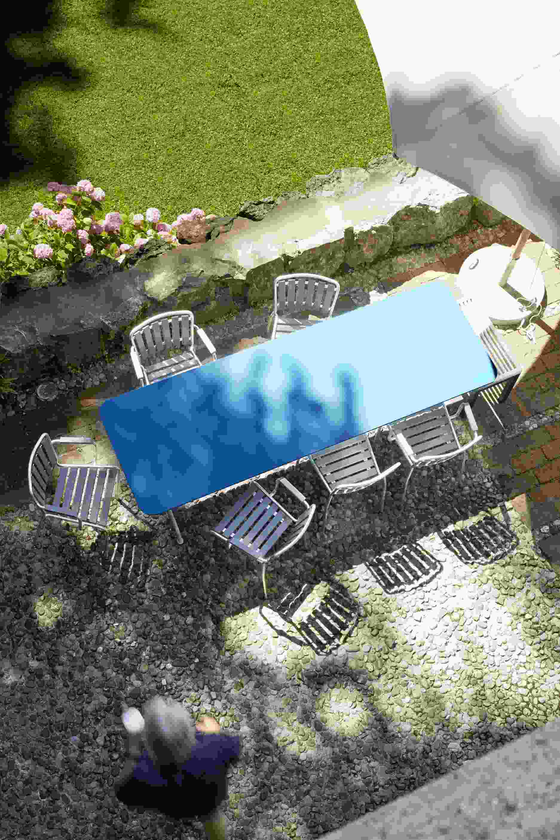 Aschgrauer Haefeli Sessel von Embru im Outdoor-Bereich mit Tisch und weiteren Gartenmöbeln.