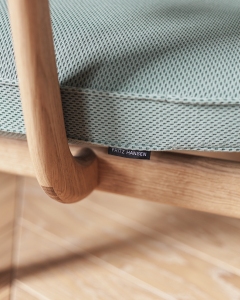 Detailaufnahme: Fritz Hansen Fred Loungesessel mit hellblauem Bezug und Holzrahmen, modernes Designmöbel.