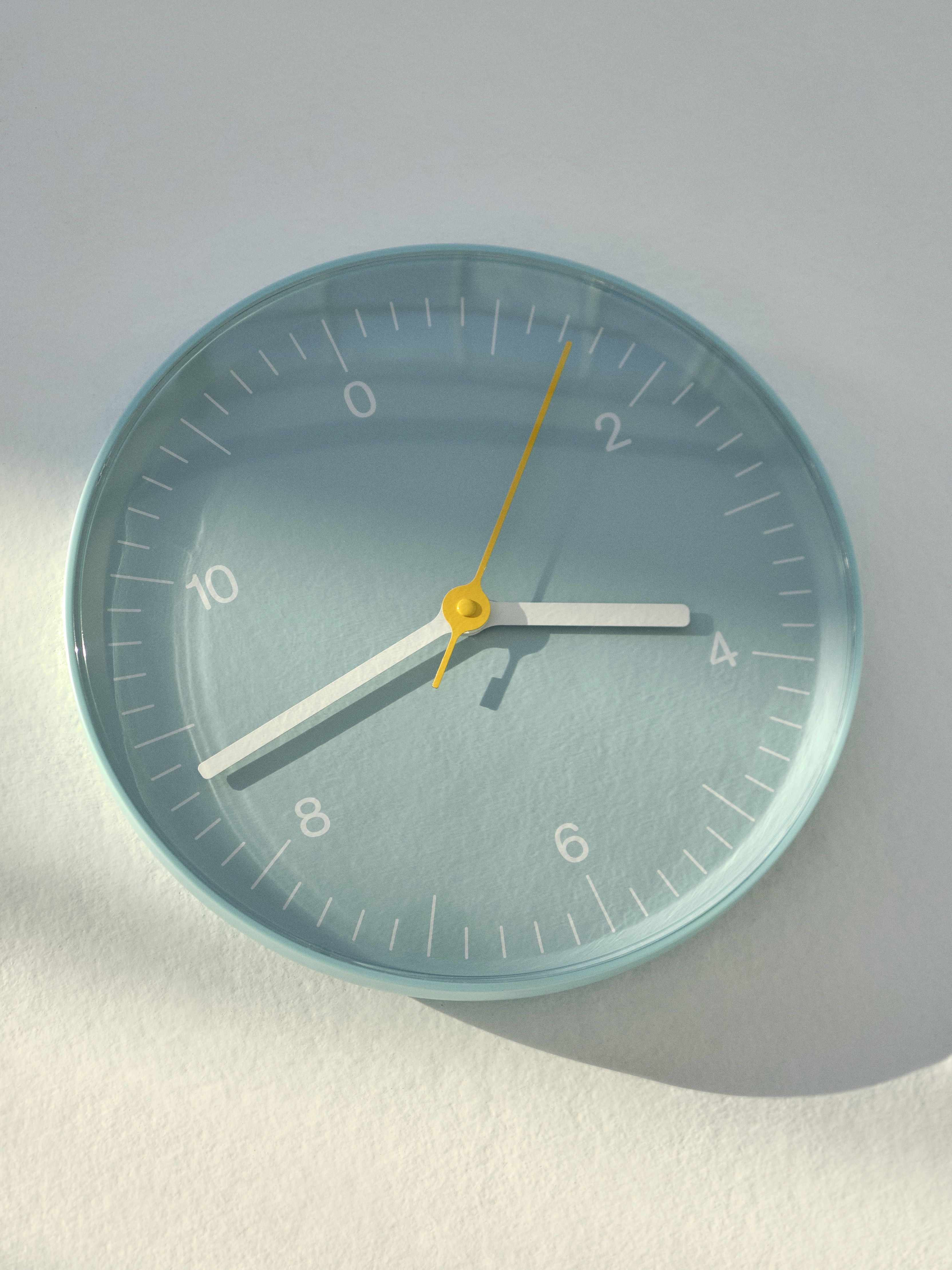 Helle blaue Hay Wanduhr mit gelben Akzenten, moderne Dekoration für Wohnzimmer und Küche.