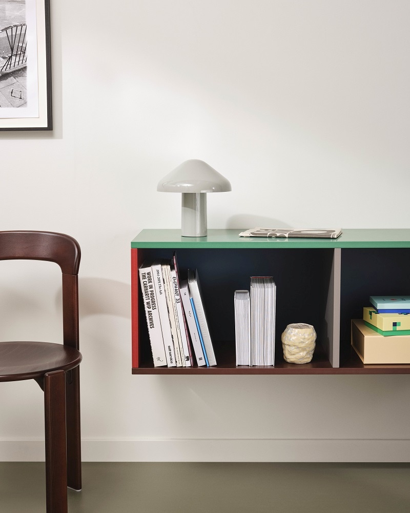 Colour Cabinet Sideboard mit mintfarbener Glasplatte, Bücher und Lampe im modernen Wohnzimmer.