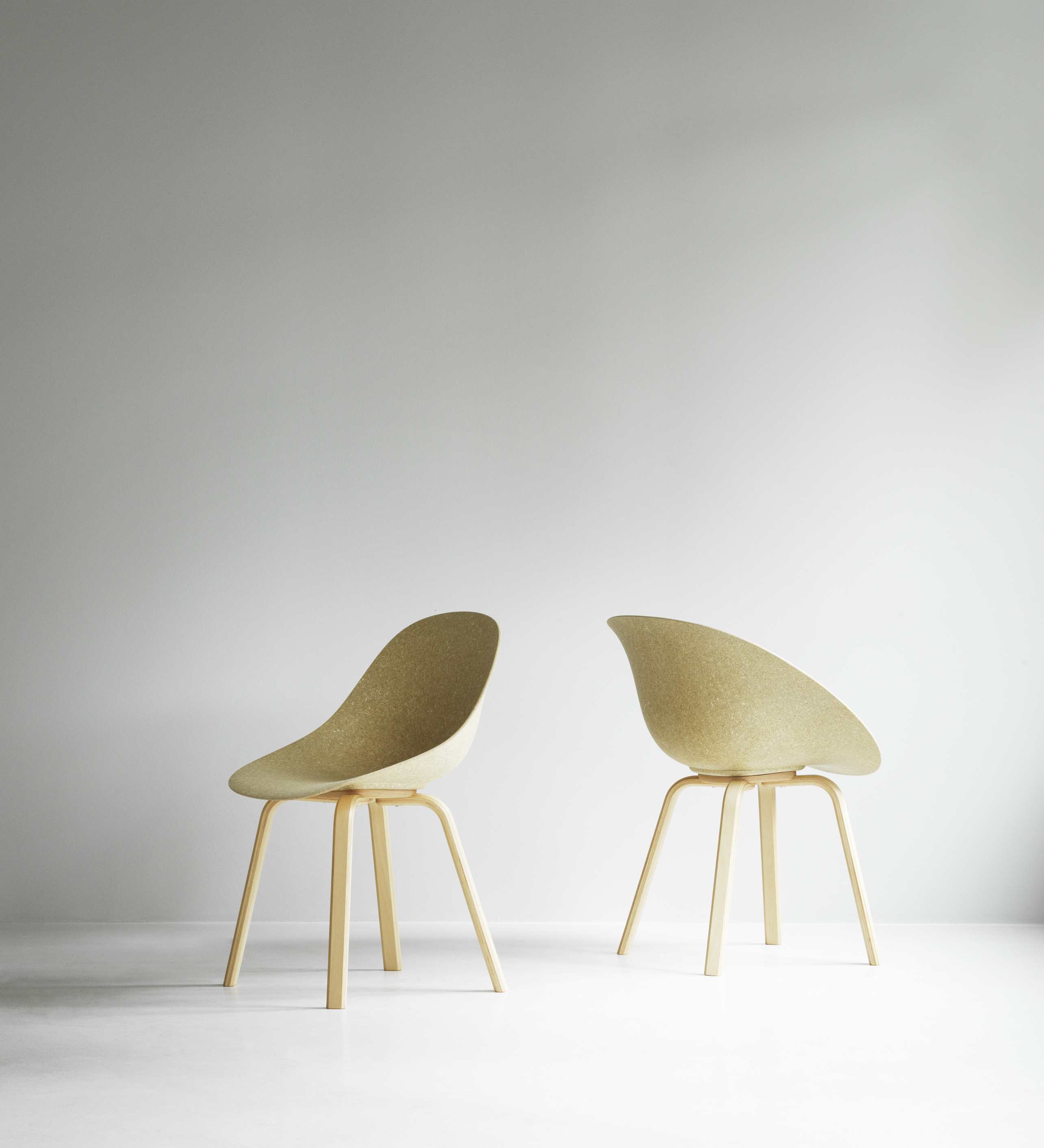 Zwei Normann Copenhagen Mat Chair Holz Stühle in Beige mit Holzbeinen vor weißem Hintergrund.
