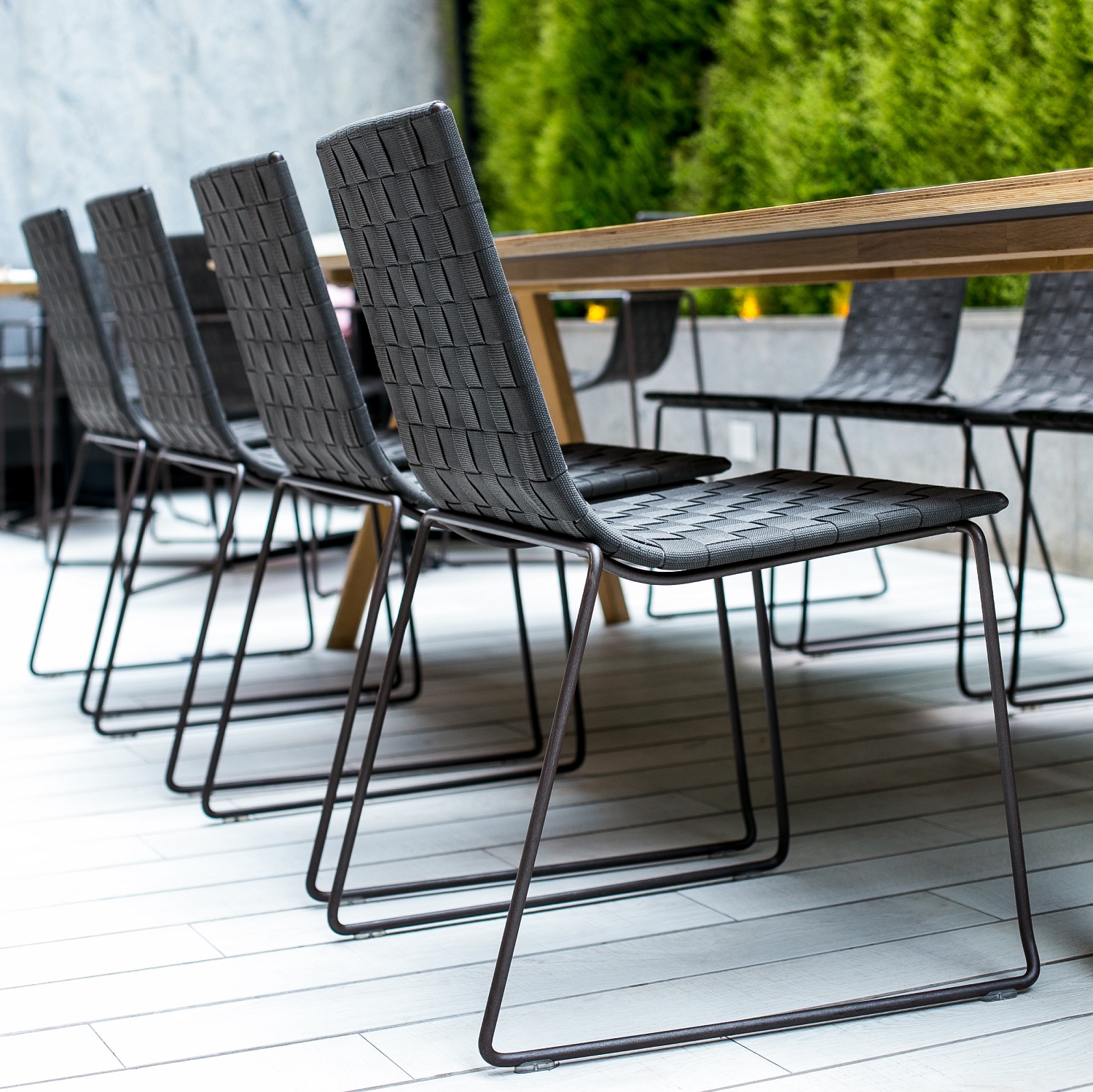 Reihe von Trenza Stühlen SI0700 von Andreu World im Außenbereich, stapelbare Outdoor-Stühle mit geflochtener Sitzfläche.