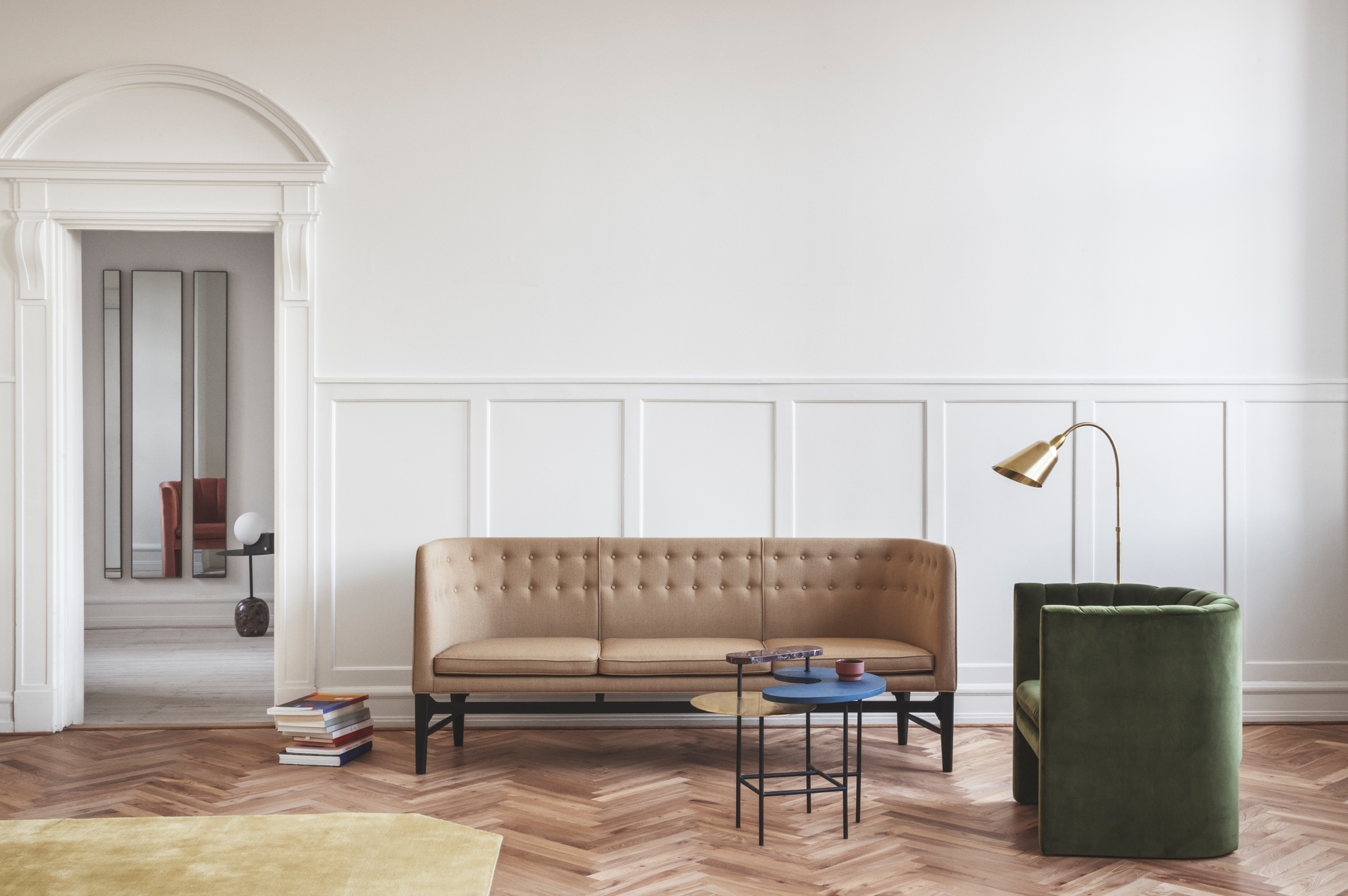 AndTradition Mayor Sofa, ein beiges 3-Sitzer Sofa mit Knopfleiste im modernen Wohnzimmer mit Parkettboden.