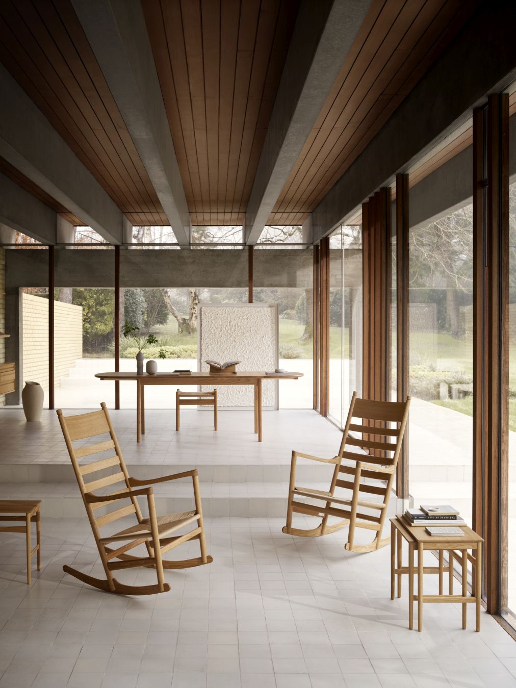 Helle Innenaufnahme mit zwei CH45 Schaukelstühlen von Carl Hansen, Tisch und Stuhl im Hintergrund.