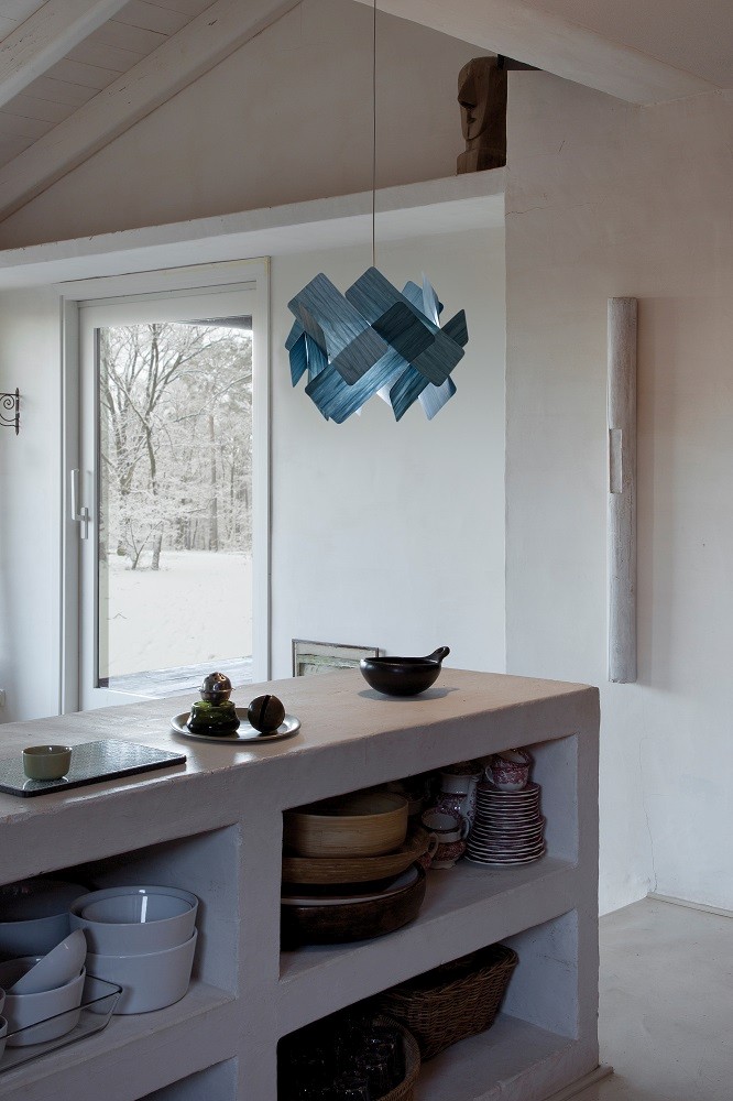 Blaue Escape LED Pendelleuchte von LZF Lamps über Küchentheke mit Geschirr und Blick nach draußen.