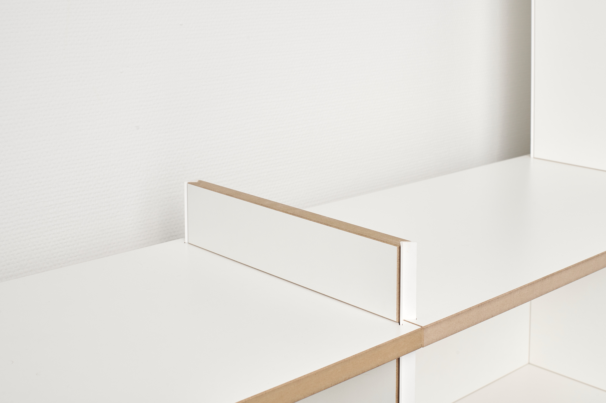Detailaufnahme: Weißes Tojo Regal Anbaumodul, Mehrfachregal aus Holz, modernes Regalsystem für Wohnzimmer und Büro.