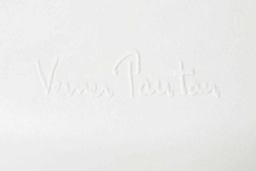 Detailaufnahme der Signatur "Verner Panton" auf einem weißen Panton Chair Kunststoffstuhl.