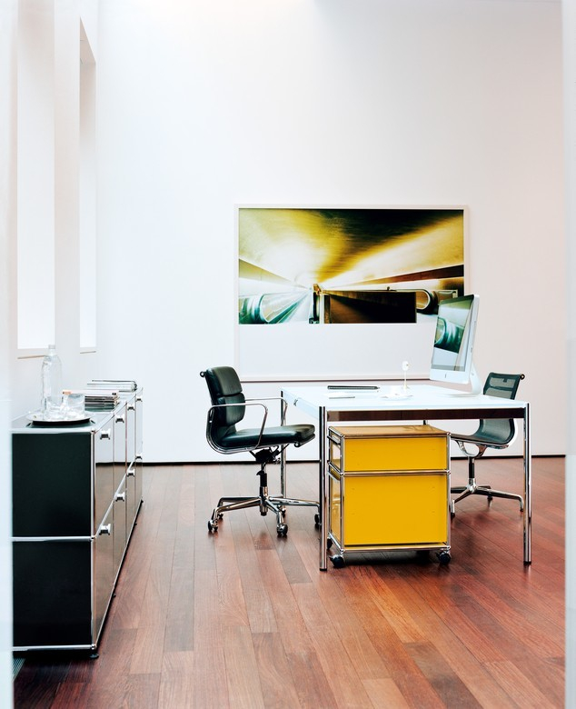 Büro mit USM Haller Rollcontainer in Enzianblau unter Schreibtisch, Stauraum und Büromöbel.
