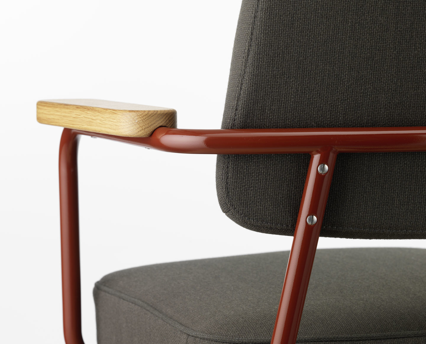 Detailaufnahme des Vitra Fauteuil Direction Pivotant Bürodrehstuhls mit braunem Gestell, Holzarmlehne und grauem Stoffbezug.
