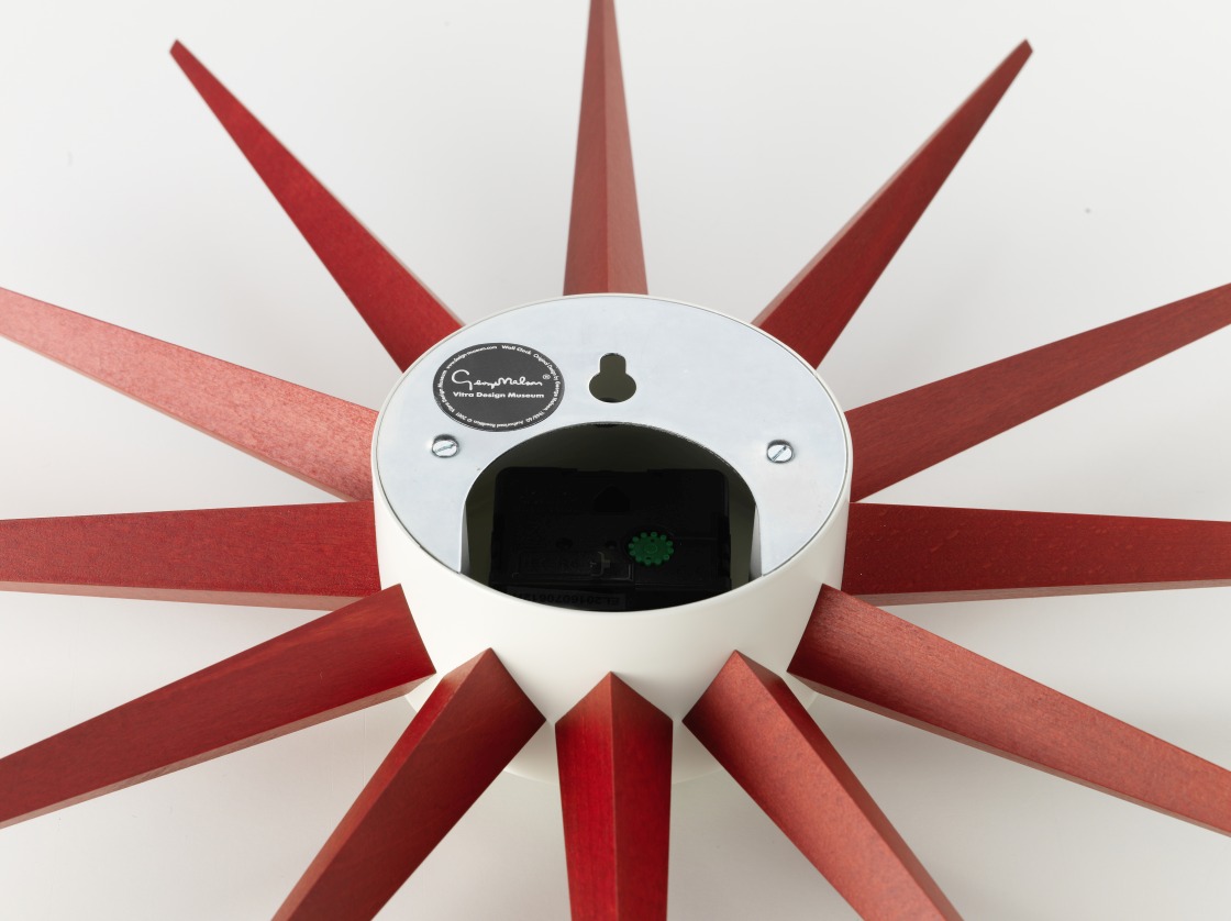 Rückansicht der Sunburst Clock Wanduhr von Vitra mit roten Holzstrahlen und Uhrwerk.