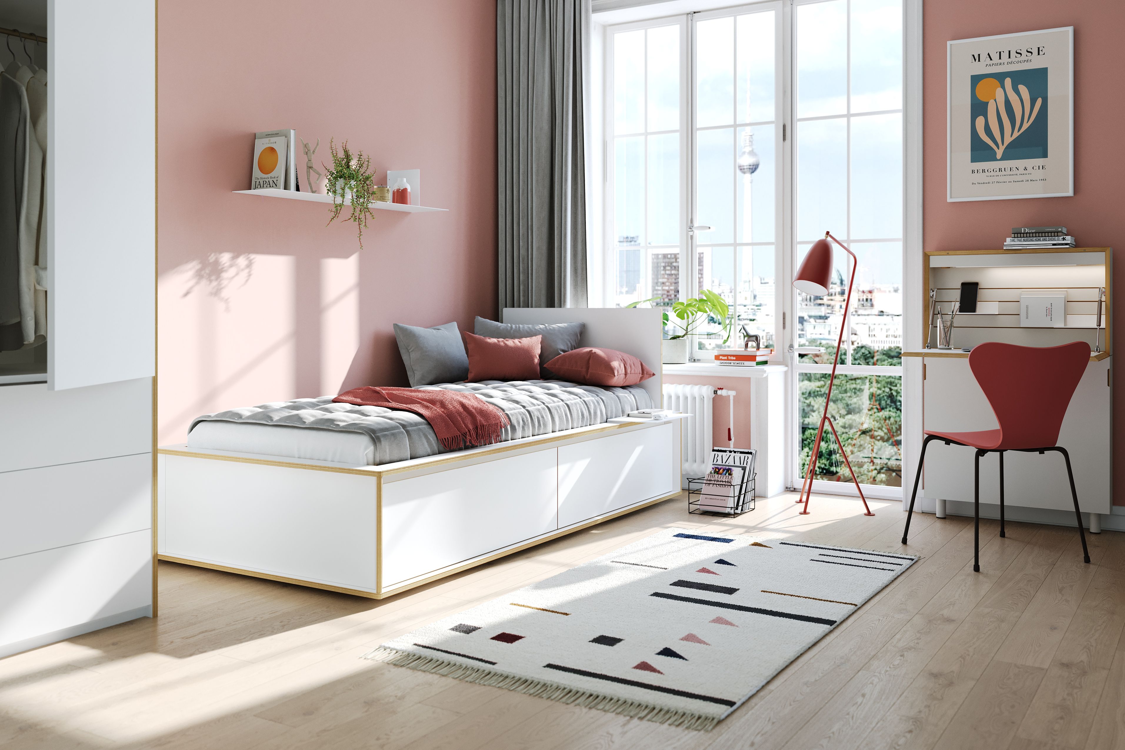 Helles Schlafzimmer mit Spaze Bett von Müller Möbelwerkstätten, Schreibtisch, roter Lampe und Teppich.