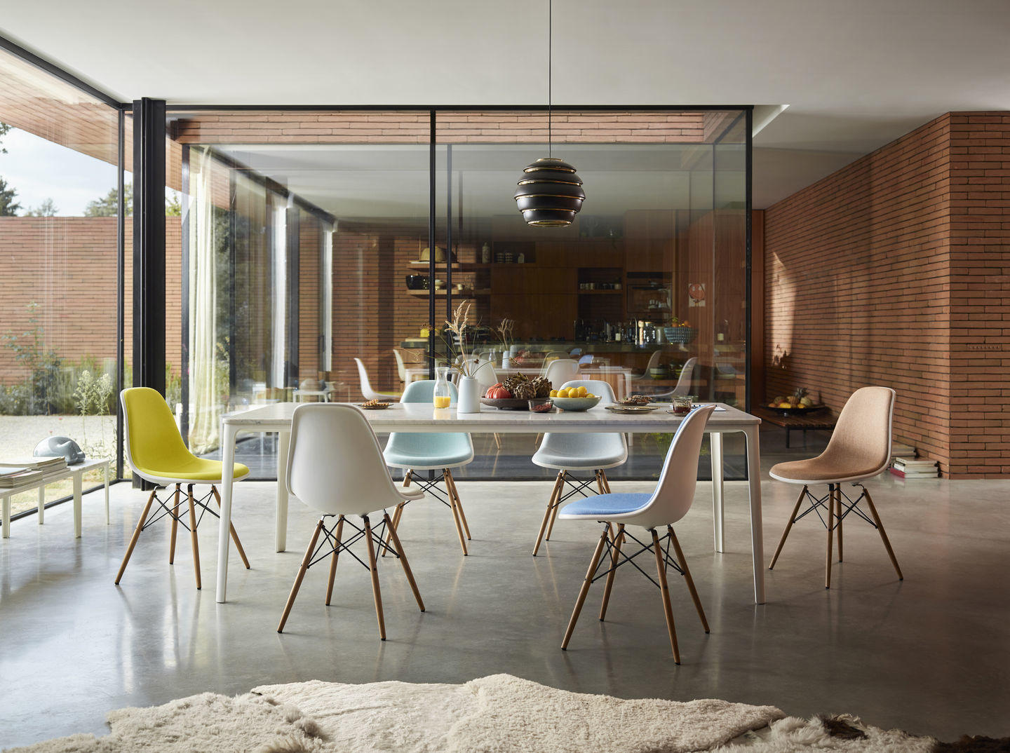 Esszimmer mit Eames Plastic Side Chairs DSW von Vitra in verschiedenen Farben und Sitzpolstern.