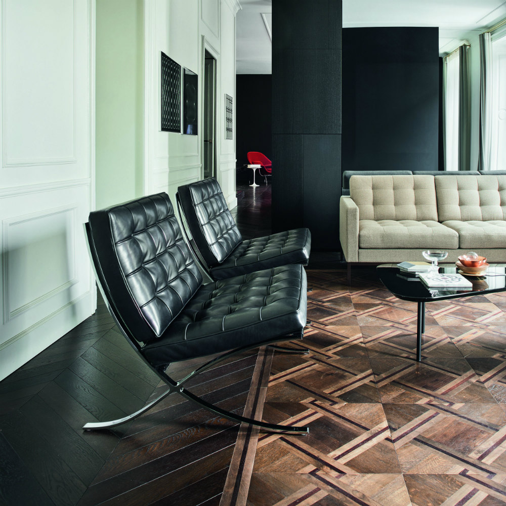 Zwei schwarze Barcelona Sessel von Knoll International im modernen Wohnzimmer mit Parkettboden.