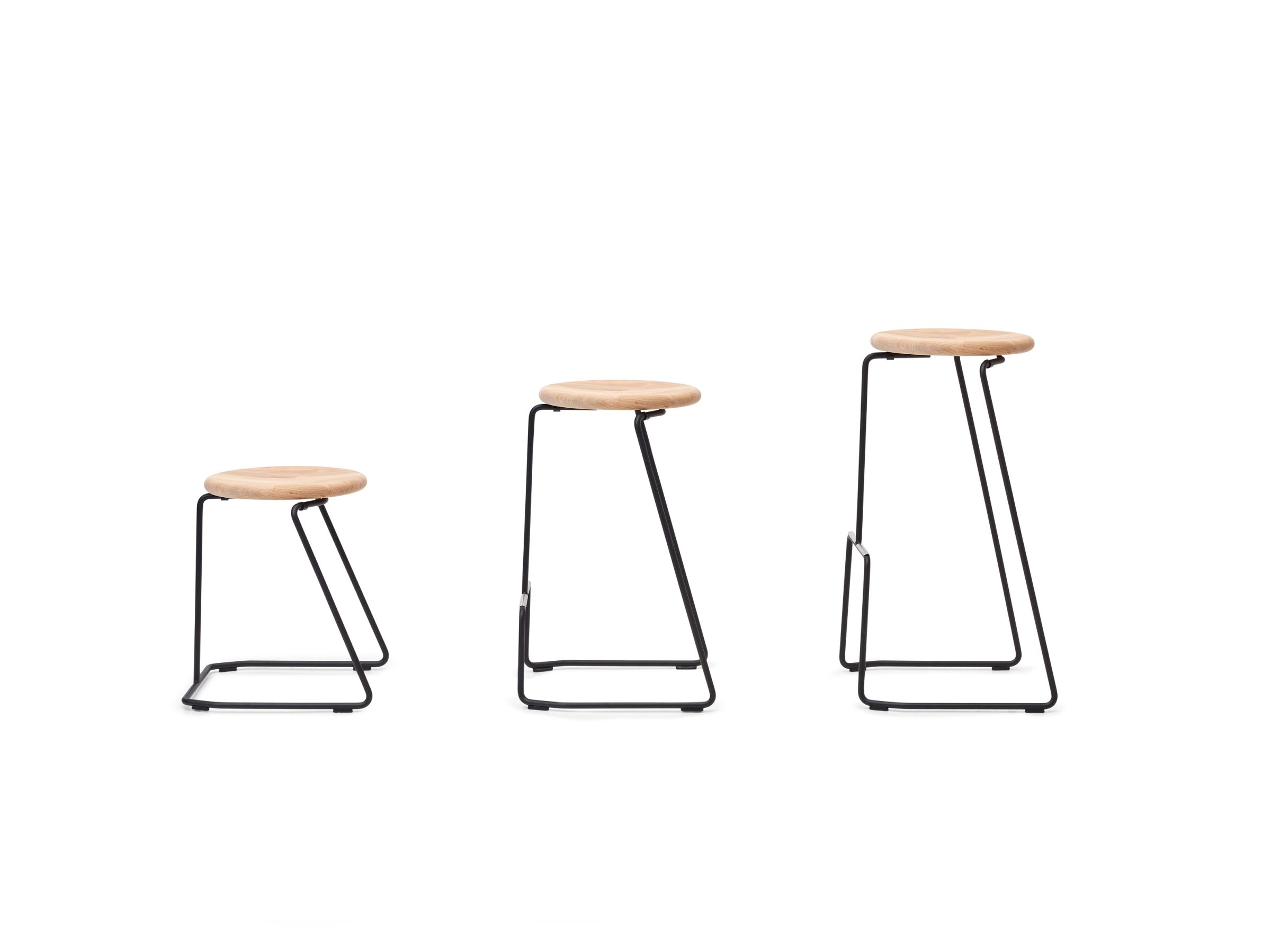 Drei Tiki Hocker von Extremis in verschiedenen Höhen, minimalistisches Design mit Holzsitzen und schwarzem Metallgestell.