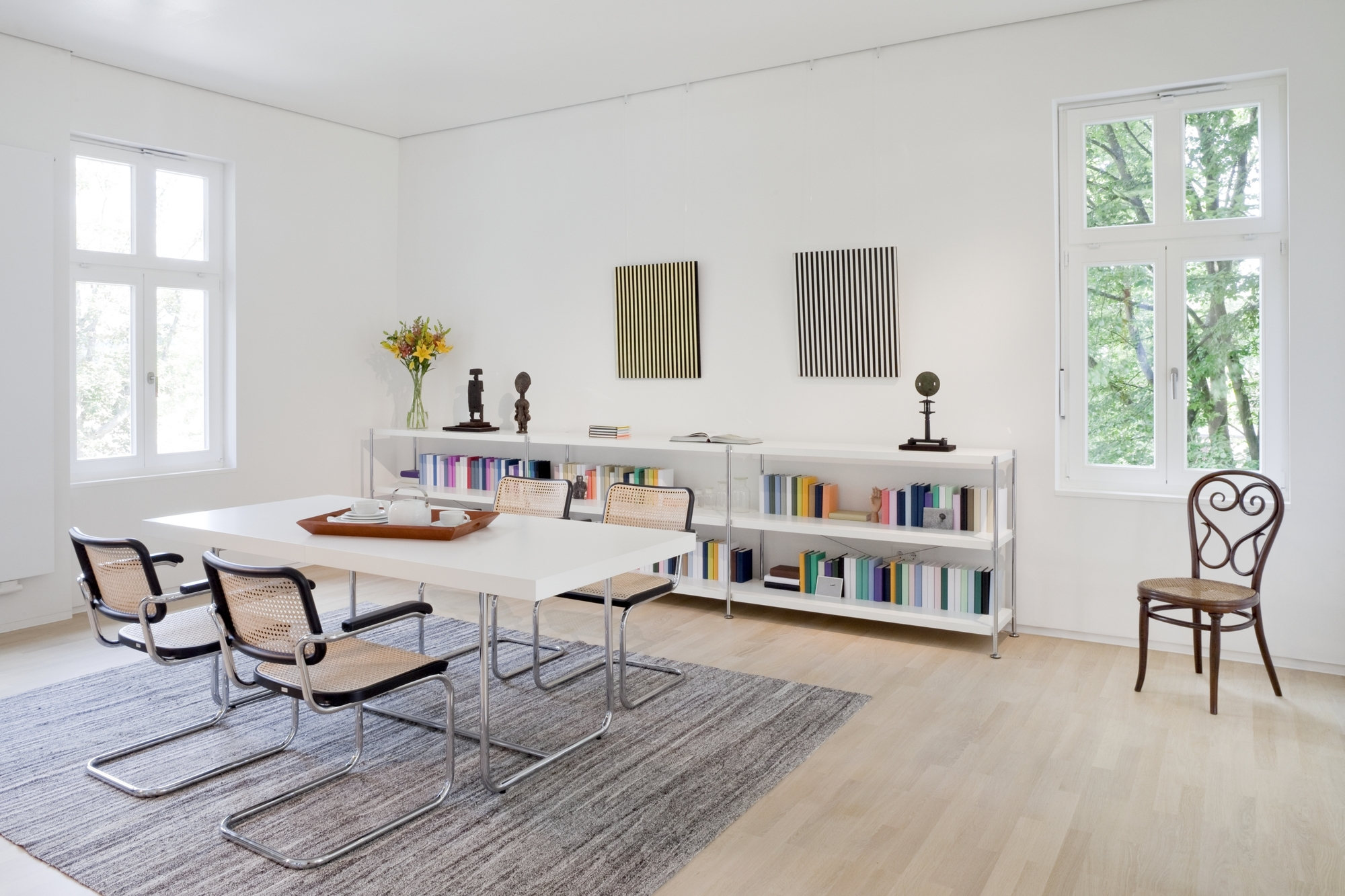 Weißer S 1071 Thonet Esstisch ausziehbar mit Freischwinger Stühlen und Teegeschirr in hellem Esszimmer.