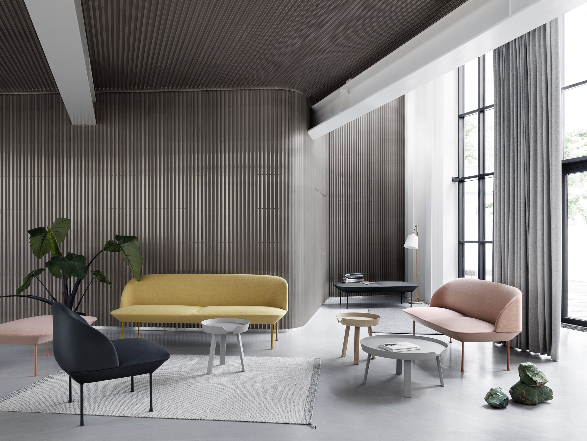 Helles Wohnzimmer mit gelbem Muuto Oslo 3-Sitzer Sofa, rosa Sessel und modernem Design für Wohnraumgestaltung.