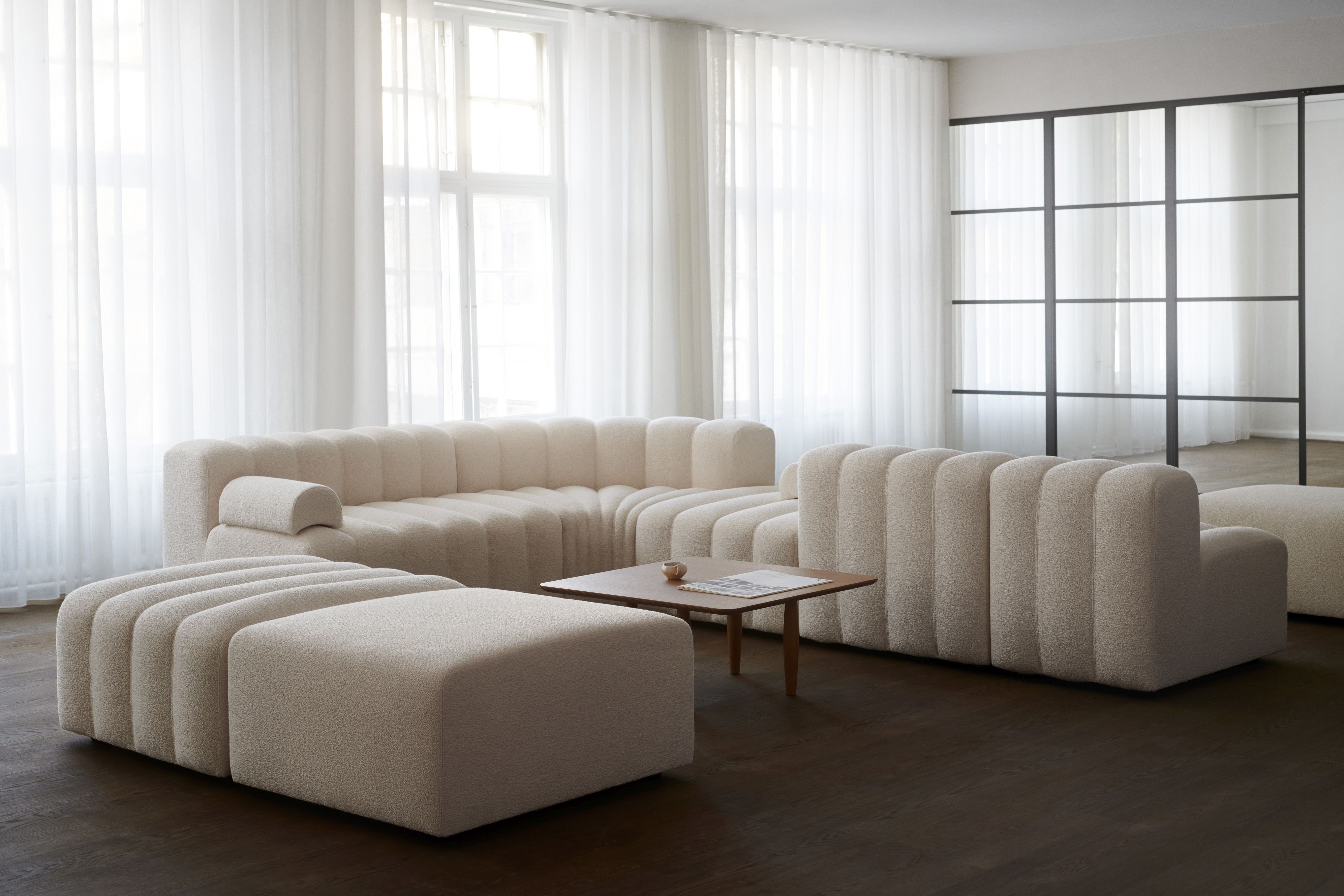 Oku Couchtisch Eiche hell geräuchert von Norr11 in modernem Wohnzimmer mit Sofa und Hocker.
