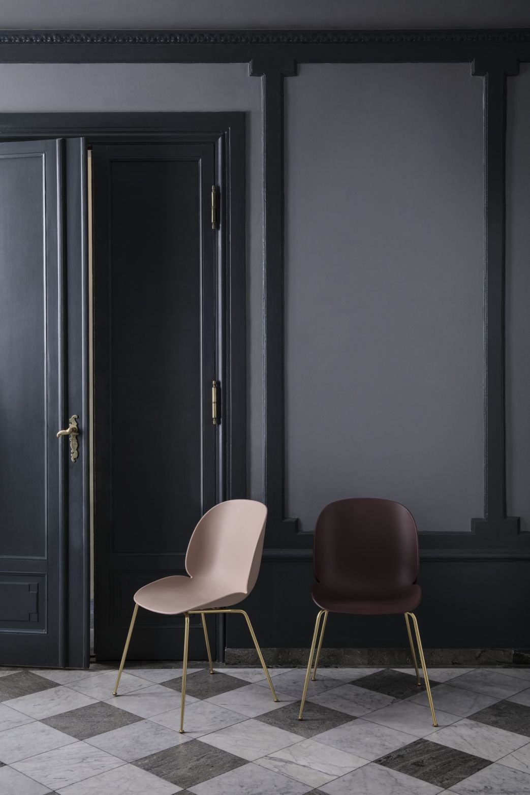 Beetle Chair Esszimmerstuhl in Alabaster White und Braun mit konischem Messinggestell vor dunkler Wand.