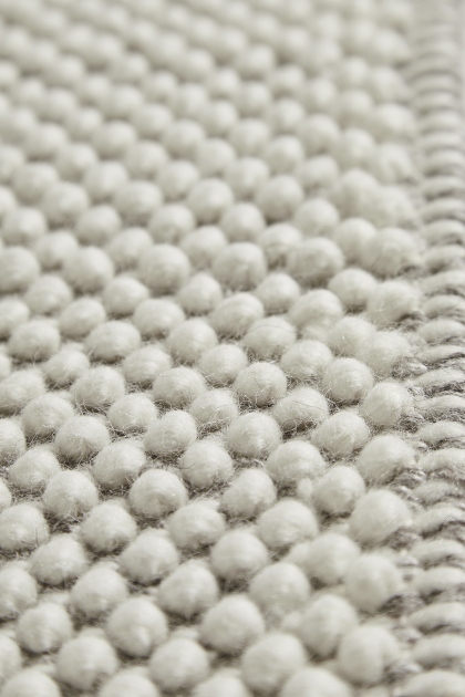 Detailaufnahme des Tact Rug Teppichs von Woud, 90x140 cm, mit strukturierter Oberfläche.
