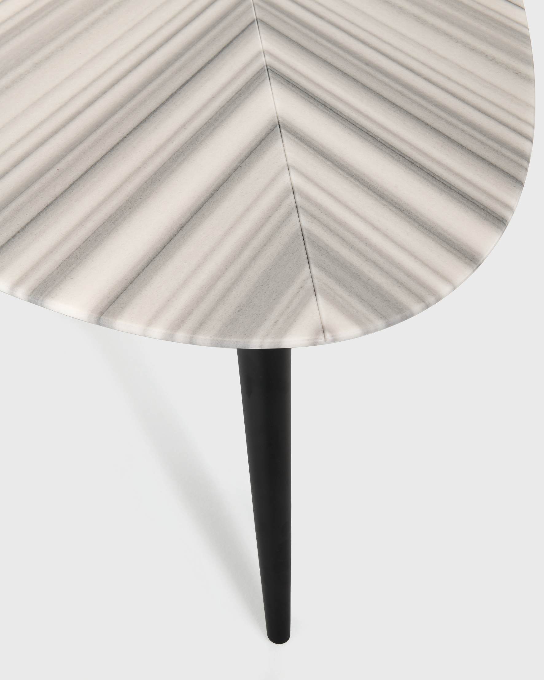 Detailaufnahme des Zanotta Tweed Marble Esstischs mit Marmorplatte und schwarzem Bein.