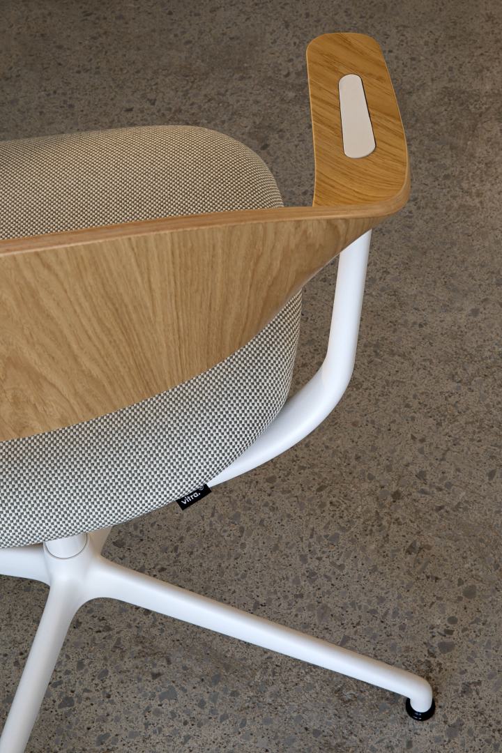 Detailaufnahme des Vitra Mynt Bürodrehstuhls mit hellem Holzrahmen und gemustertem Stoffbezug, ideal für modernes Bürodesign.