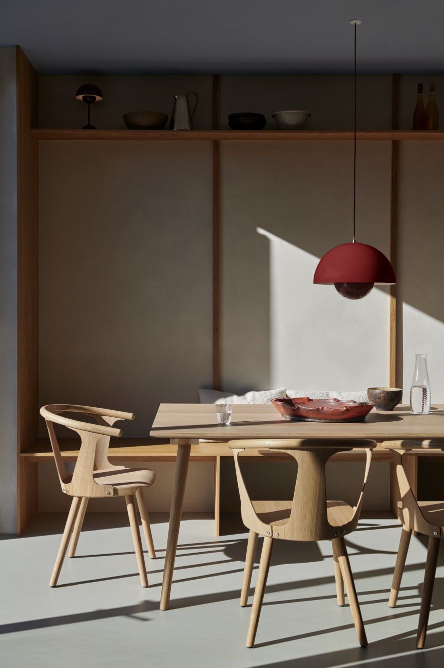 Rote Flowerpot VP7 Pendelleuchte von AndTradition über Esstisch mit Holzstühlen und Geschirr.