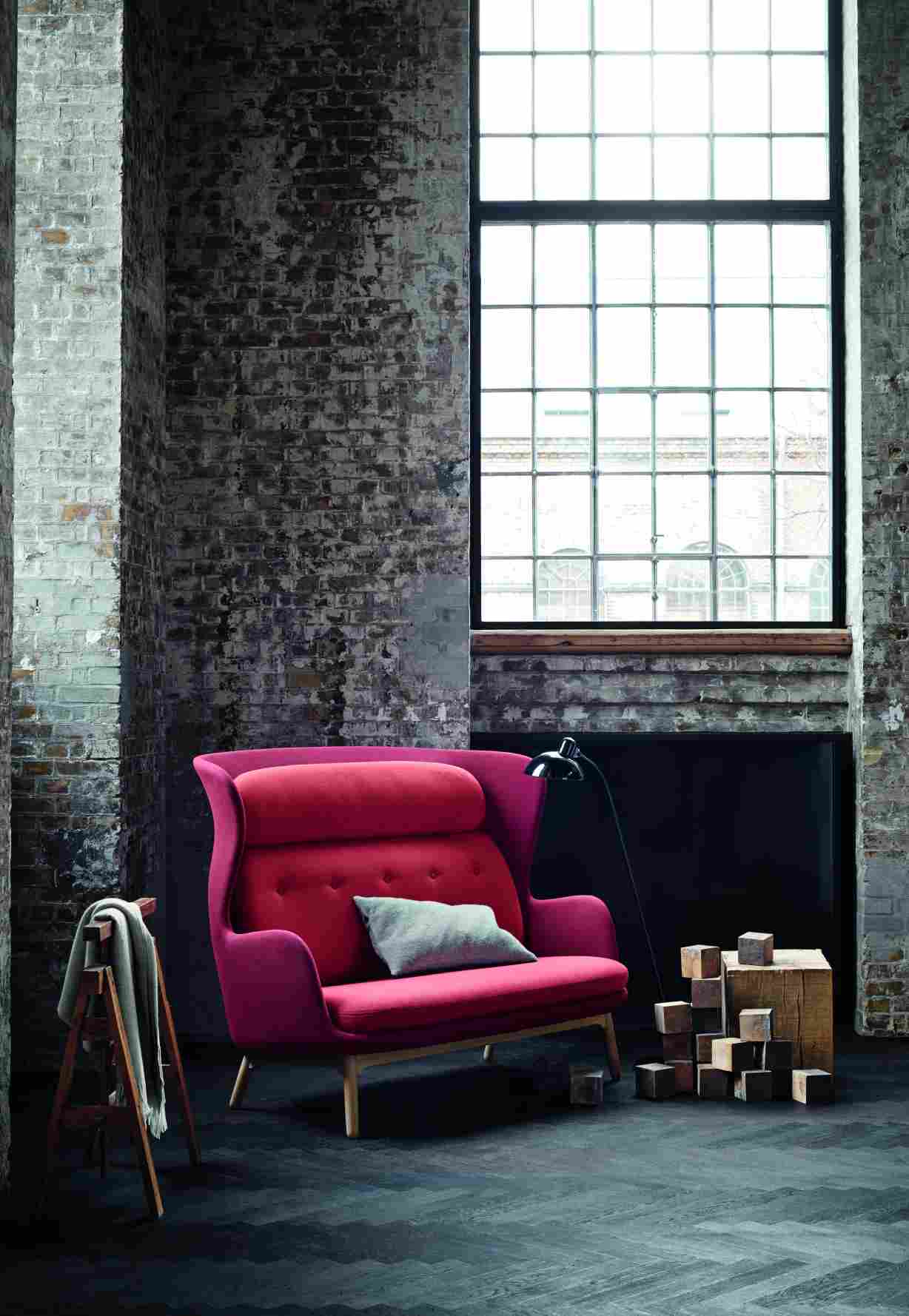Nahaufnahme des modernen Ro 2-Sitzer Sofas von Fritz Hansen in einem Loft mit Backsteinmauer.