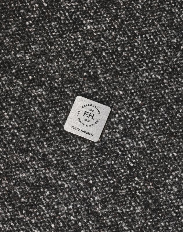 Detailaufnahme des Stoffes vom Fritz Hansen Schwan Sessel Jubiläumsmodell mit Jubiläumsplakette.