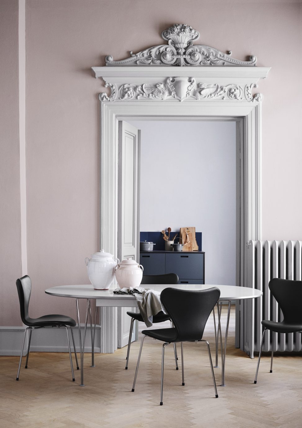 Fritz Hansen Super Elliptisch Esstisch mit Stühlen in einem stilvollen Esszimmer mit Altbau-Elementen.