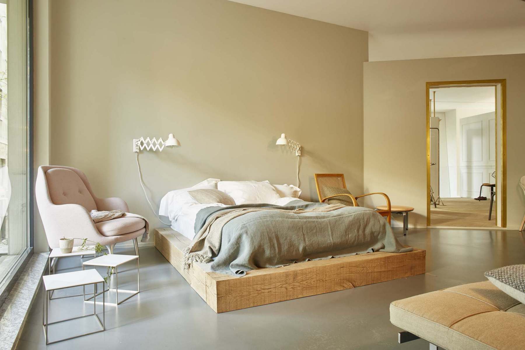 Heller Raum mit Bett und dem rosa Fri Sessel von Fritz Hansen, sowie weiteren Möbeln.