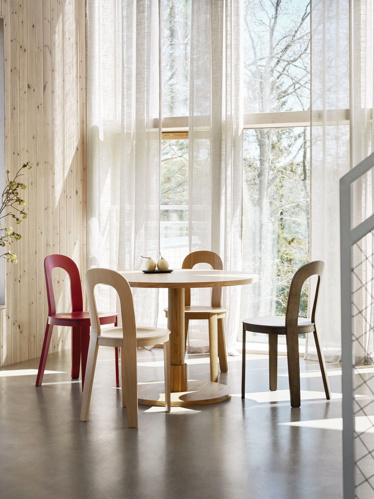 Esszimmer mit rundem Holztisch und vier Olivia Stühlen von Design House Stockholm in verschiedenen Farben.