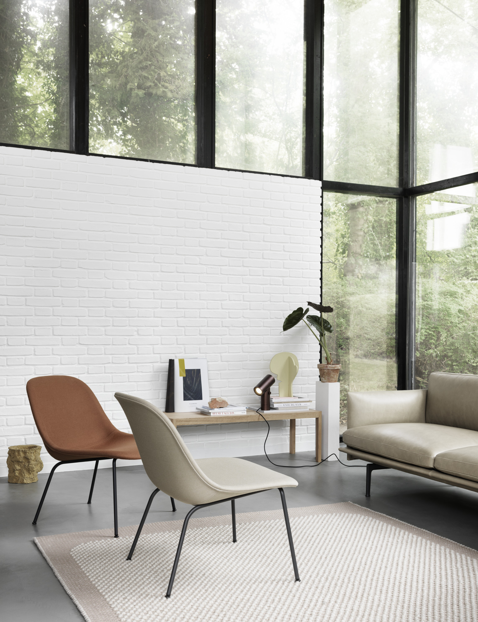 Moderne Wohnzimmer-Szene mit Muuto Beam Lamp Tischleuchte aus Aluminium auf einem Holztisch.