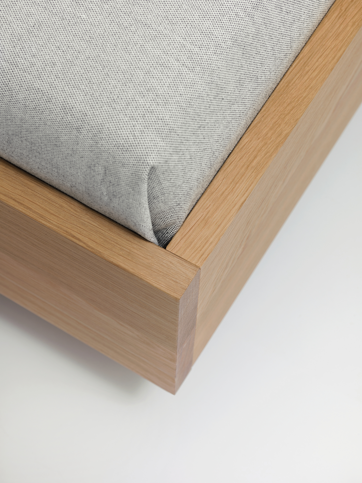 Detailaufnahme vom Simple HI Holzbett mit hellgrauem Stoffbezug und minimalistischem Design.