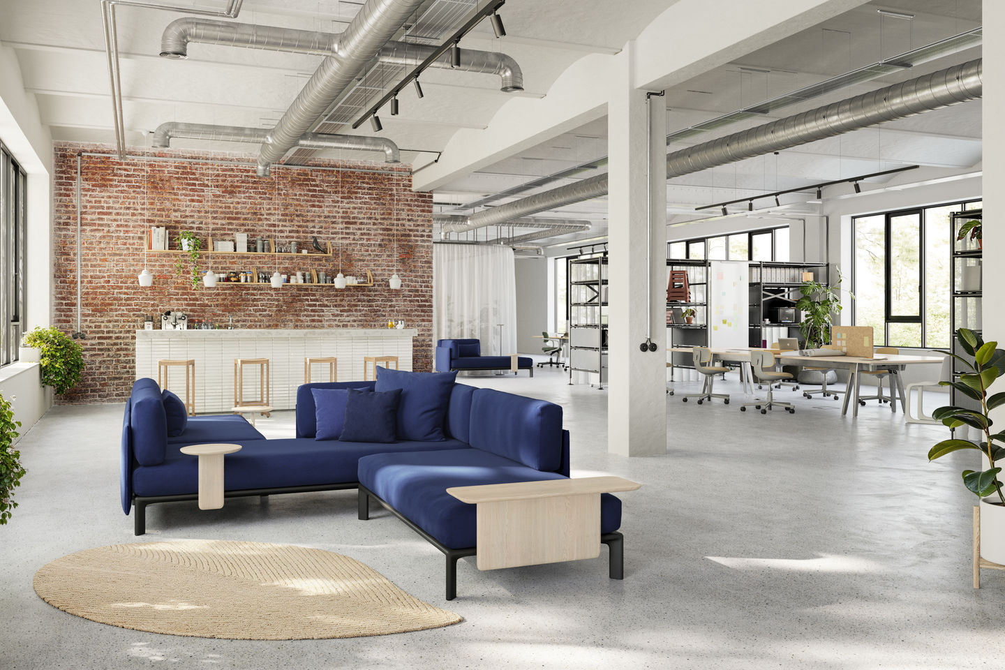 Blaues Anagram Sofa von Vitra in modernem Büro mit Teppich und Backsteinwand.