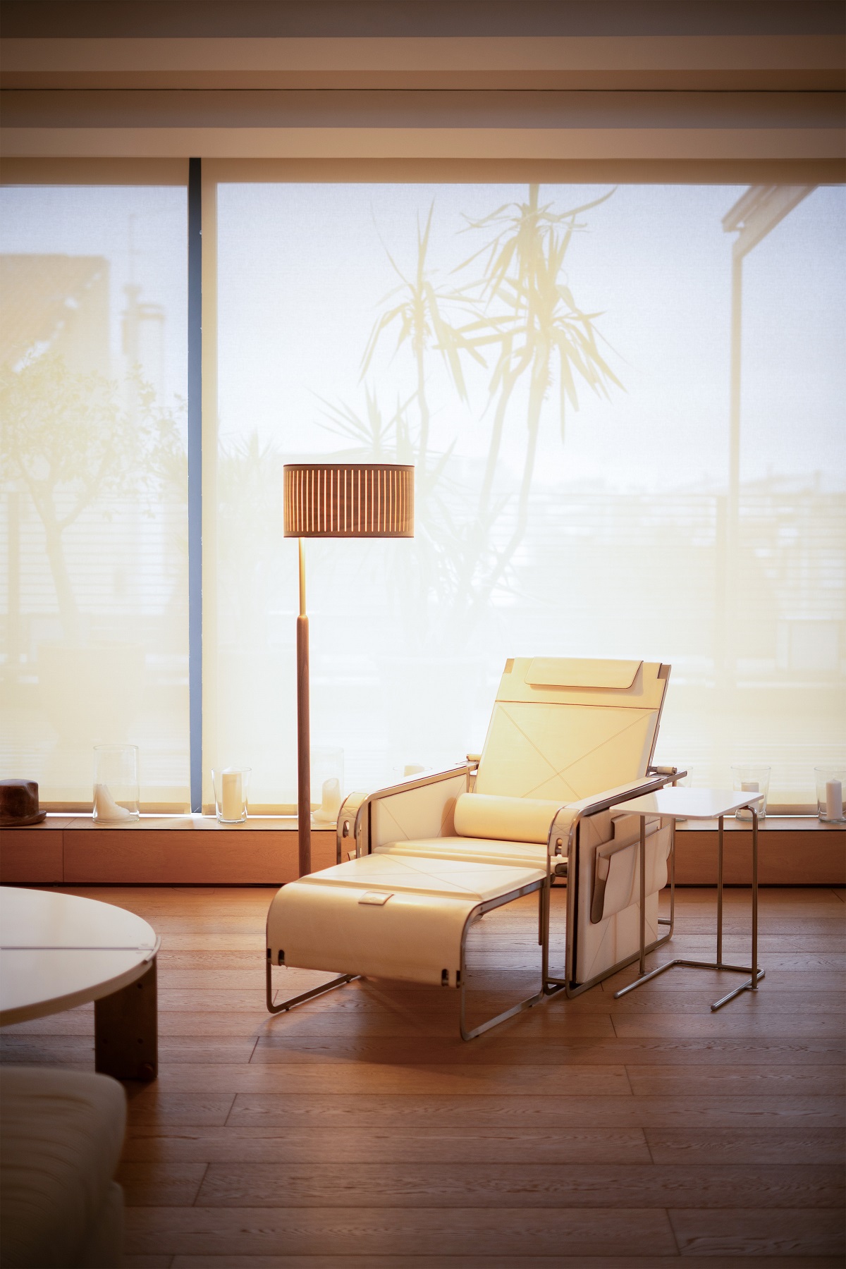 Autumn Floor Lamp Stehleuchte von Nomon neben einem Sessel in einem hellen Wohnzimmer.