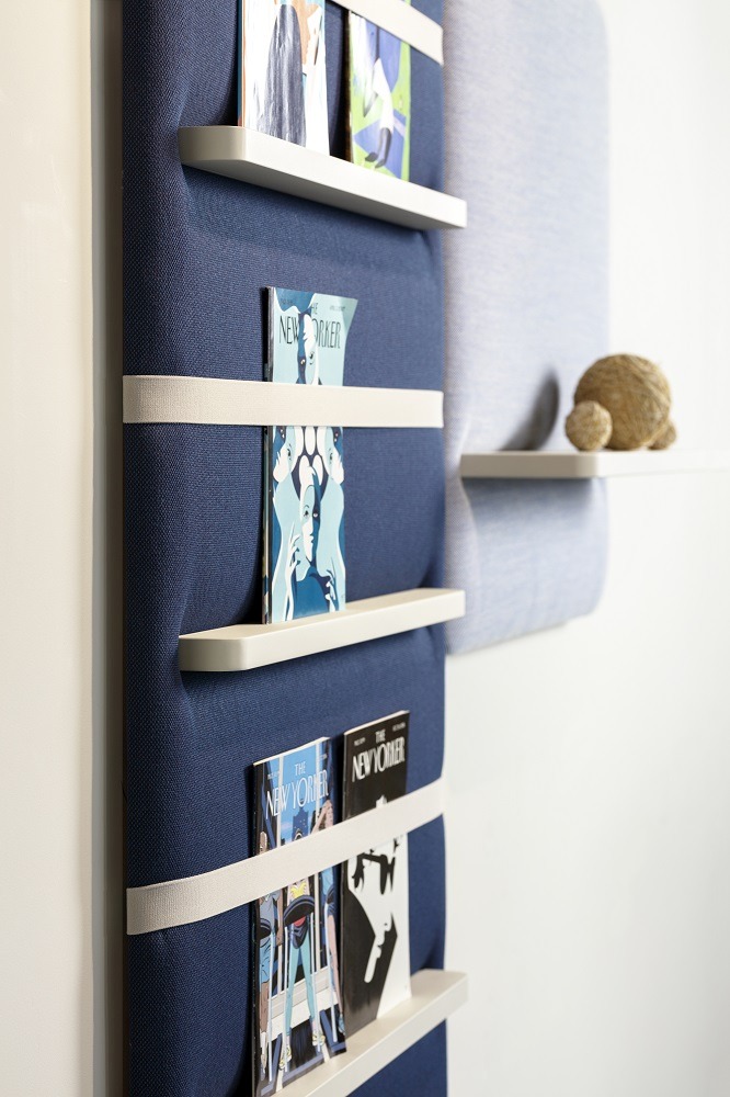 Cascando Pillow Wall Wandpaneel in Blau mit weißen Regalböden und Zeitschriften.