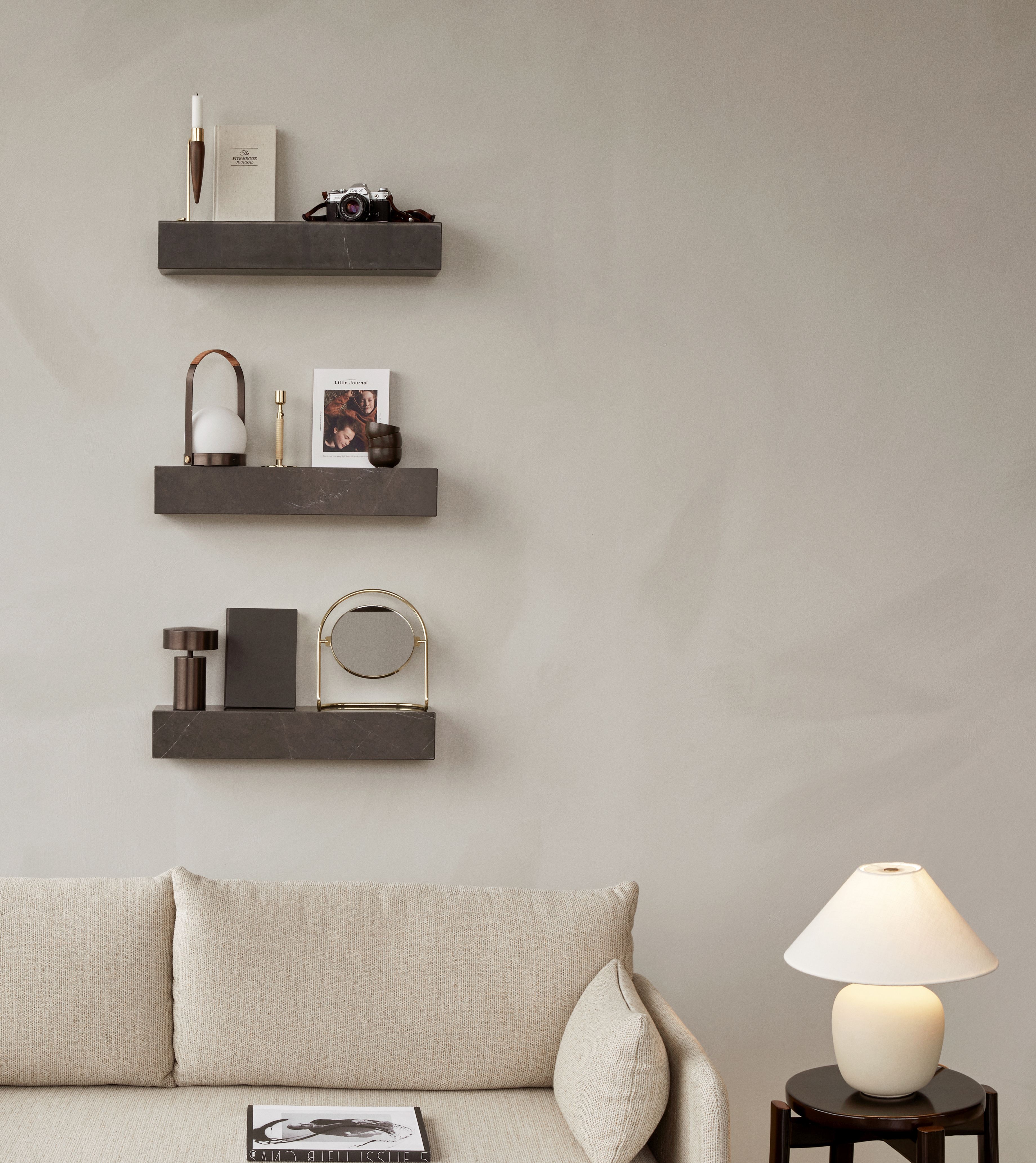Nahaufnahme von drei grauen Audo Copenhagen Plinth Regalen an einer Wand, dekoriert mit Wohnaccessoires.