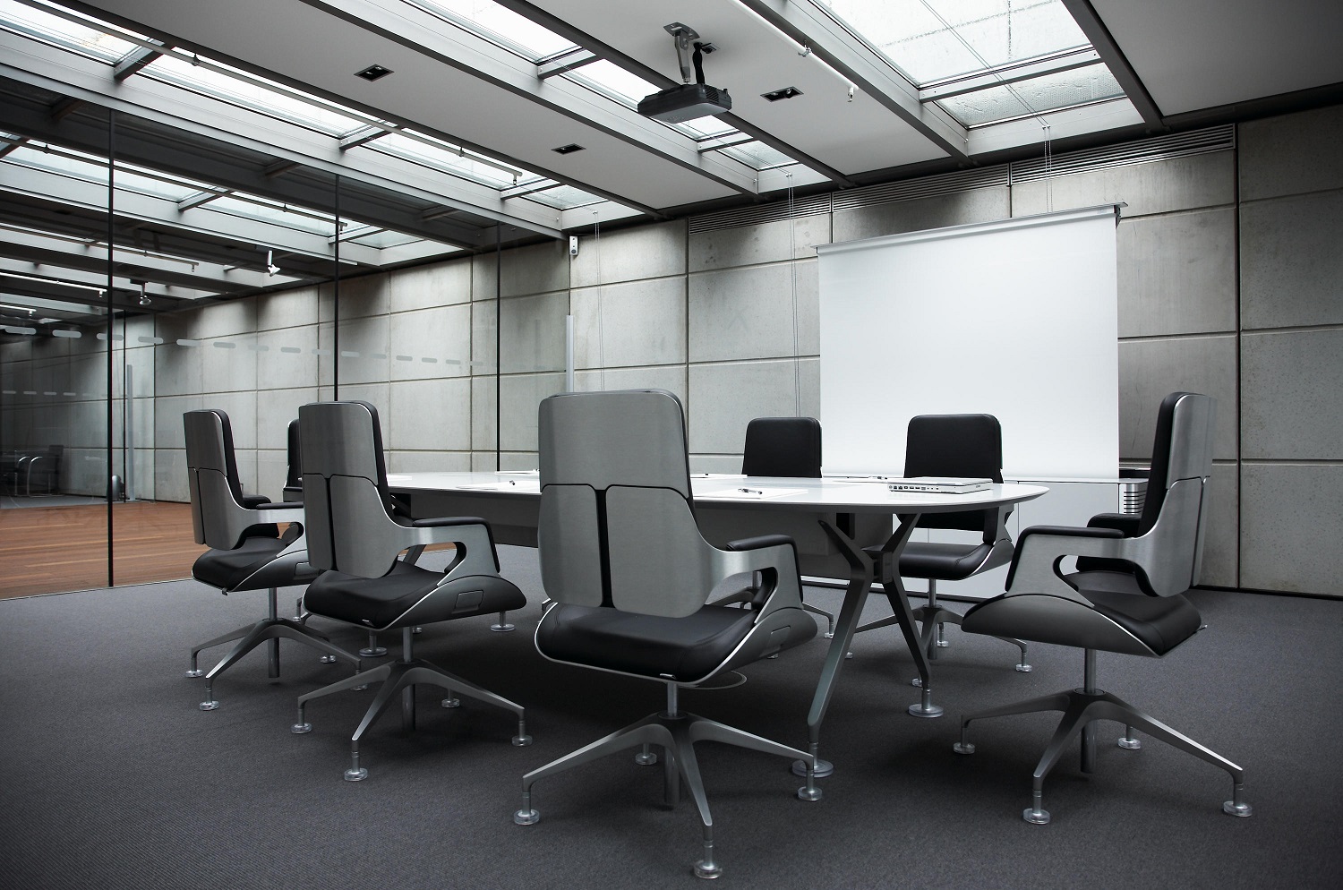 Konferenzraum mit ovalem Tisch und Interstuhl Silver Konferenzsessel mit schwarzer Lederpolsterung und silbernem Gestell.