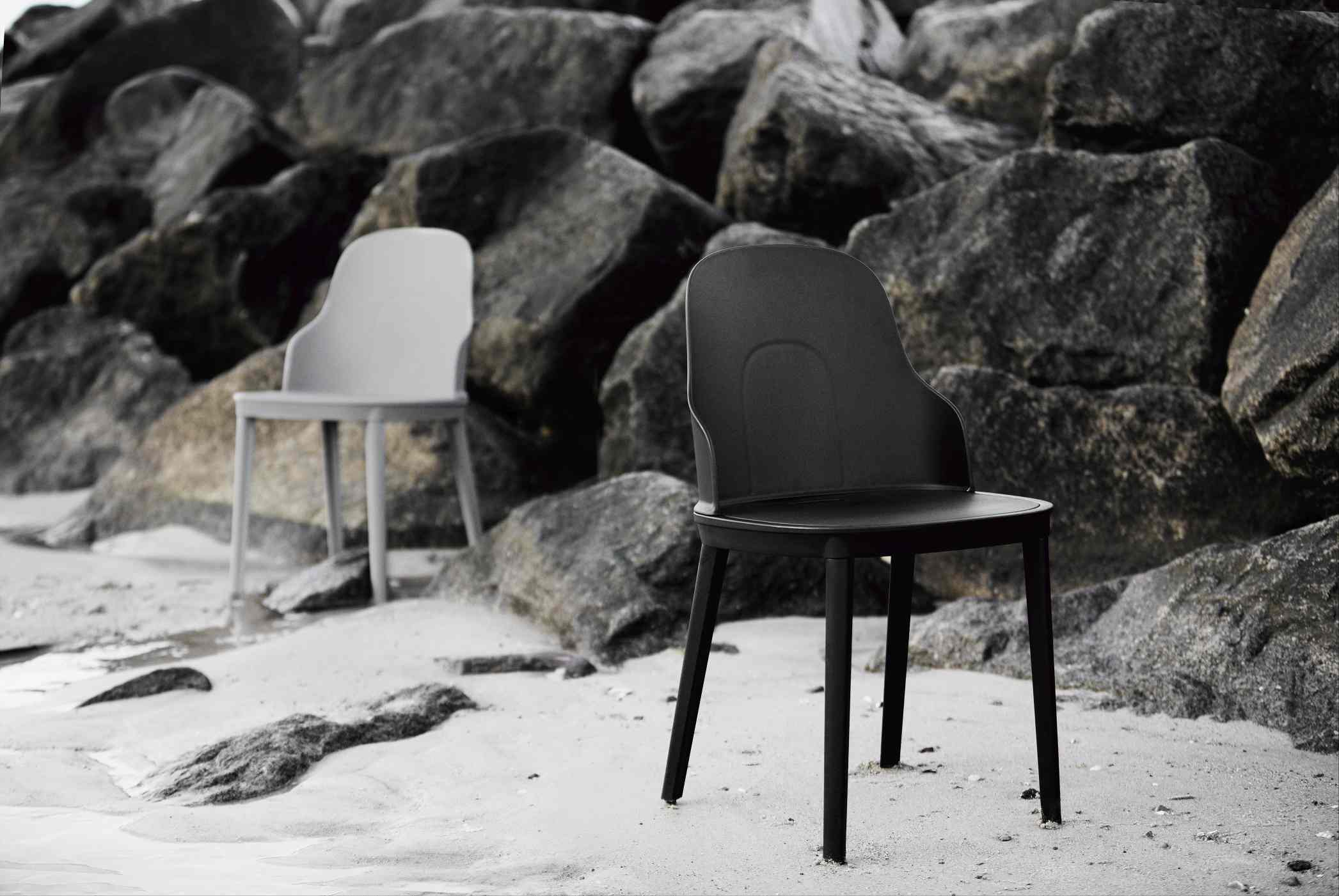 Zwei Allez Stühle von Normann Copenhagen in Schwarz und Grau am Strand vor Felsen.