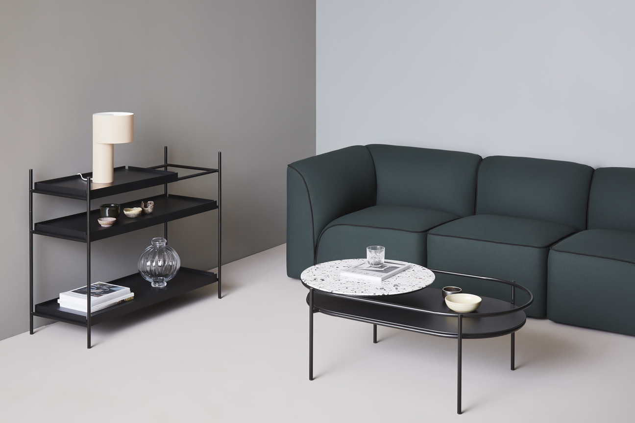Flora Modulsofa von Woud, dunkelgrün, mit Couchtisch und Regal im modernen Wohnzimmer-Ambiente.