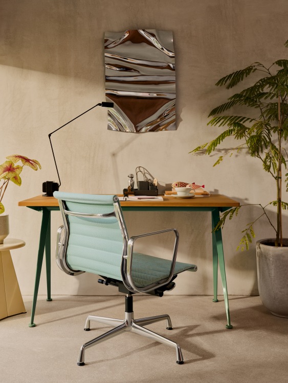 Vitra Aluminium Chair EA 132 in Hellblau vor Schreibtisch und Zimmerpflanze, Bürostuhl Designklassiker.